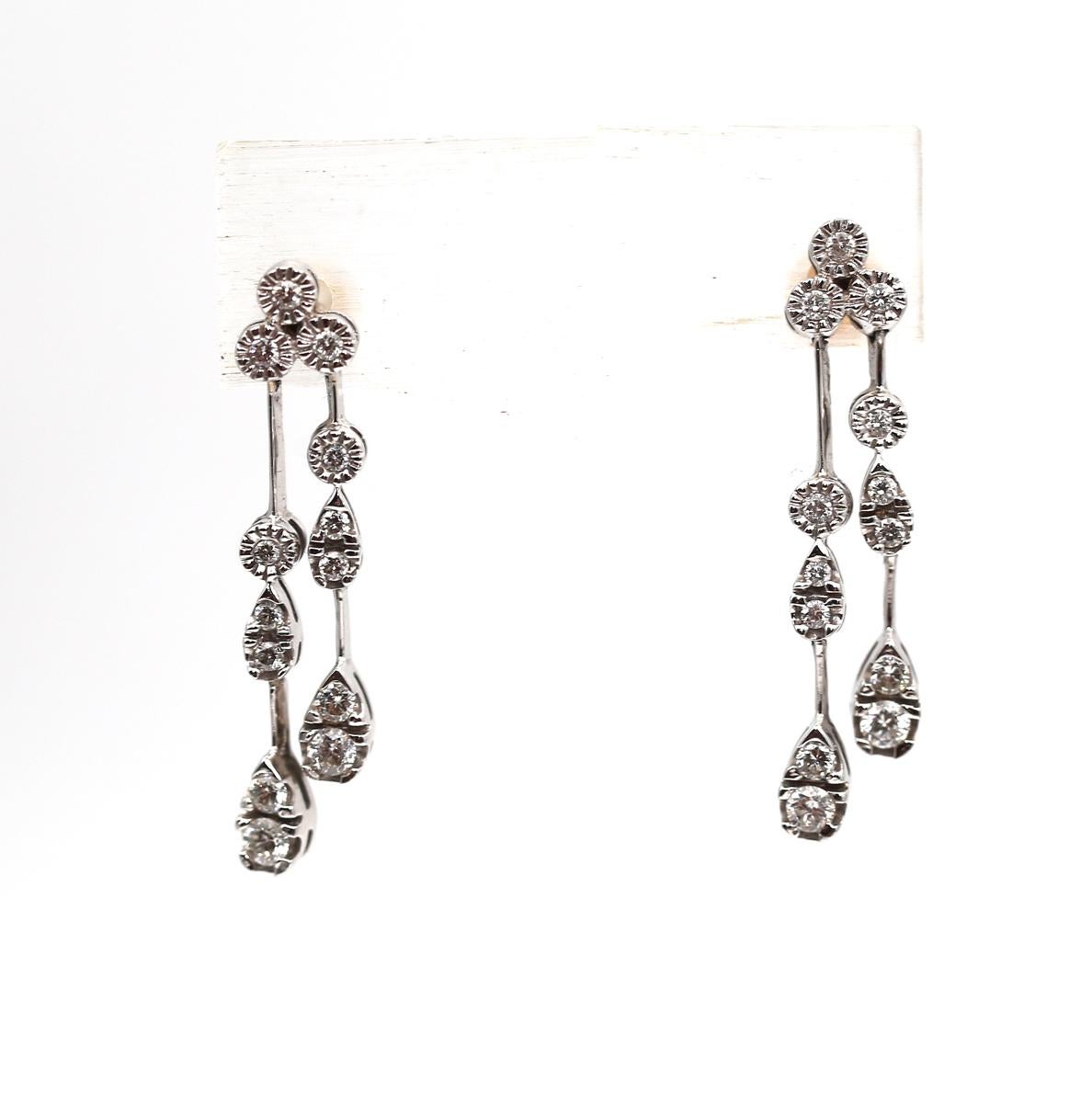 Diamond Drop Earrings 18K White Gold, created around 2000.
A Pair Of Diamond Drop Earrings in 18ct white gold, each set with a trio of round brilliant cut diamonds suspending two rows of further round brilliant cut diamonds. The links are not fixed