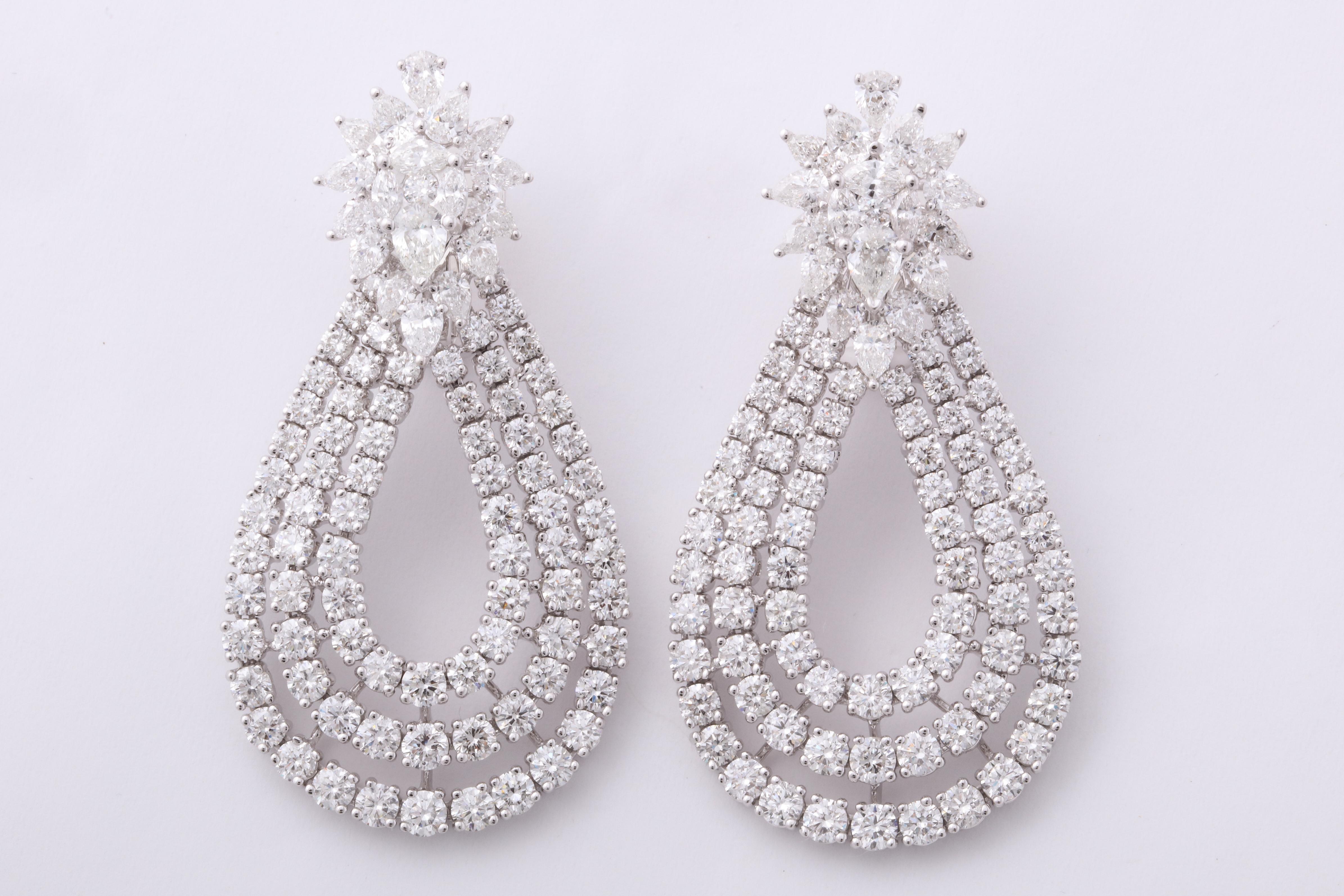 
These earrings are a WOW!!

Three rows of round diamonds set in a tear drop shape suspended from a fabulous cluster top.

15.60 carats of round, pear and marquise cut diamonds set in 18k white gold. 

Approximately 2 inches in length, approximately