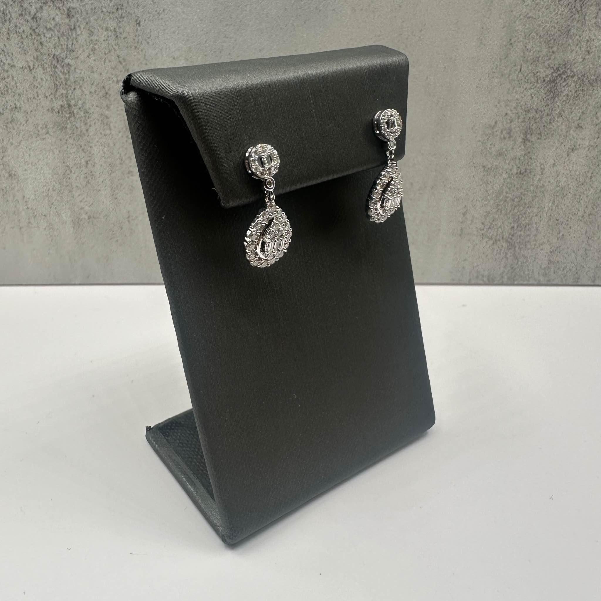 These elegant Diamond Drop Earrings in 10kt white gold feature 1ctw of natural GH SI baguette and round cut diamonds, offering a stunning blend of sparkle and sophistication. Weighing 4.1 grams, these earrings provide a substantial yet comfortable
