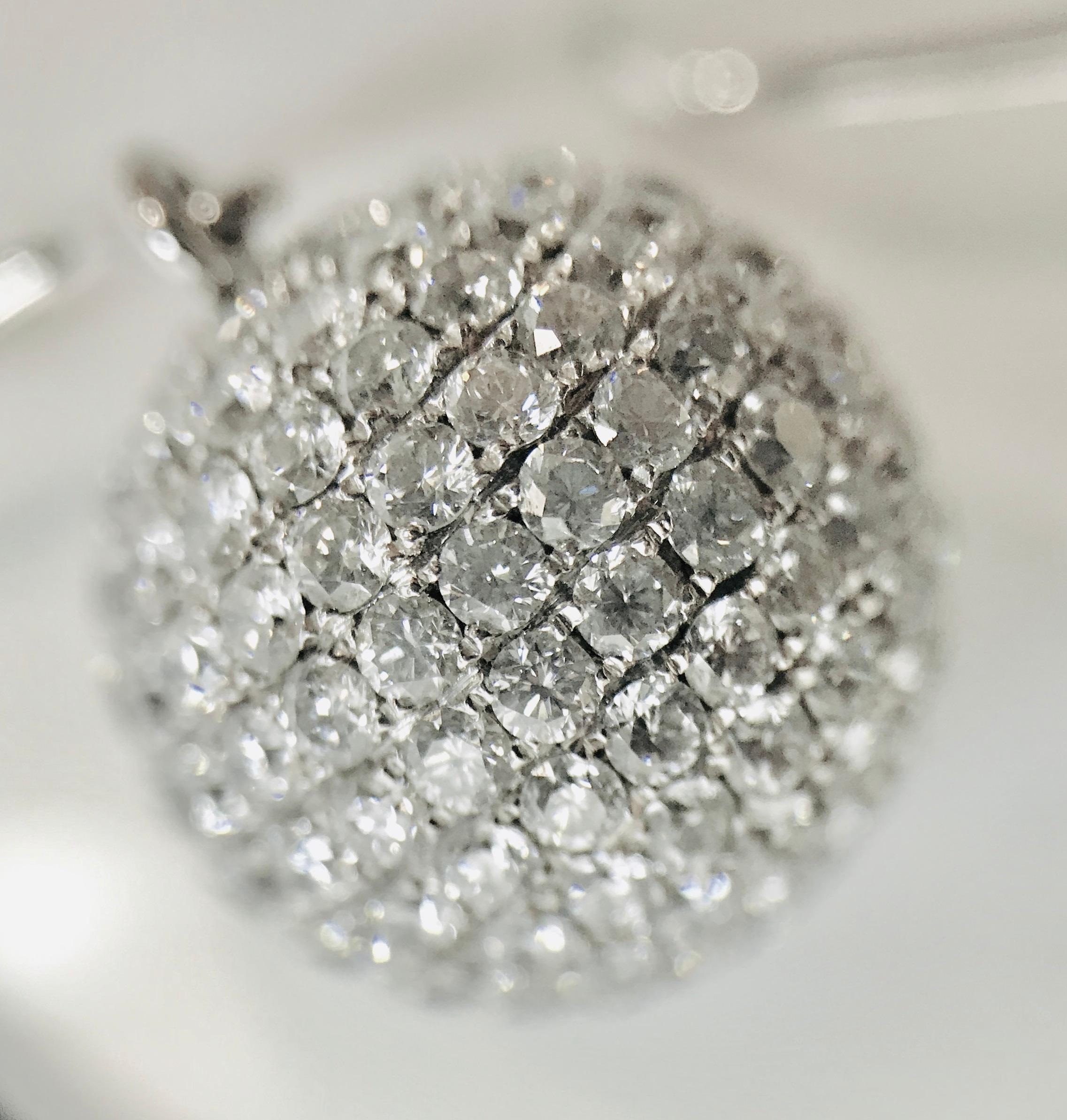 One pair of “Disco” ball-styled earrings. Each earring includes an 18K white gold wire, measuring 13 mm long, from which a 14 mm diameter diamond pavé ball drops. The round brilliant cut diamonds total approximately 7.13 cts  
and are estimated to