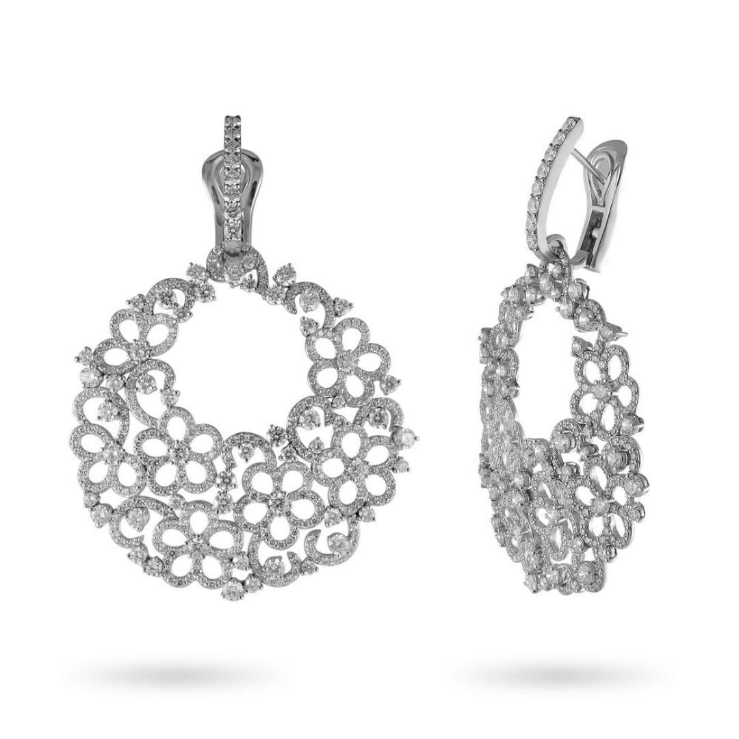 Brighten up your night gown or wedding dress with these exquisite and delicate 18k White Gold diamond drop hoop earrings that are sure to be the center of attention. With a fine and intricate flower design set with 10.62 carat total diamonds, this