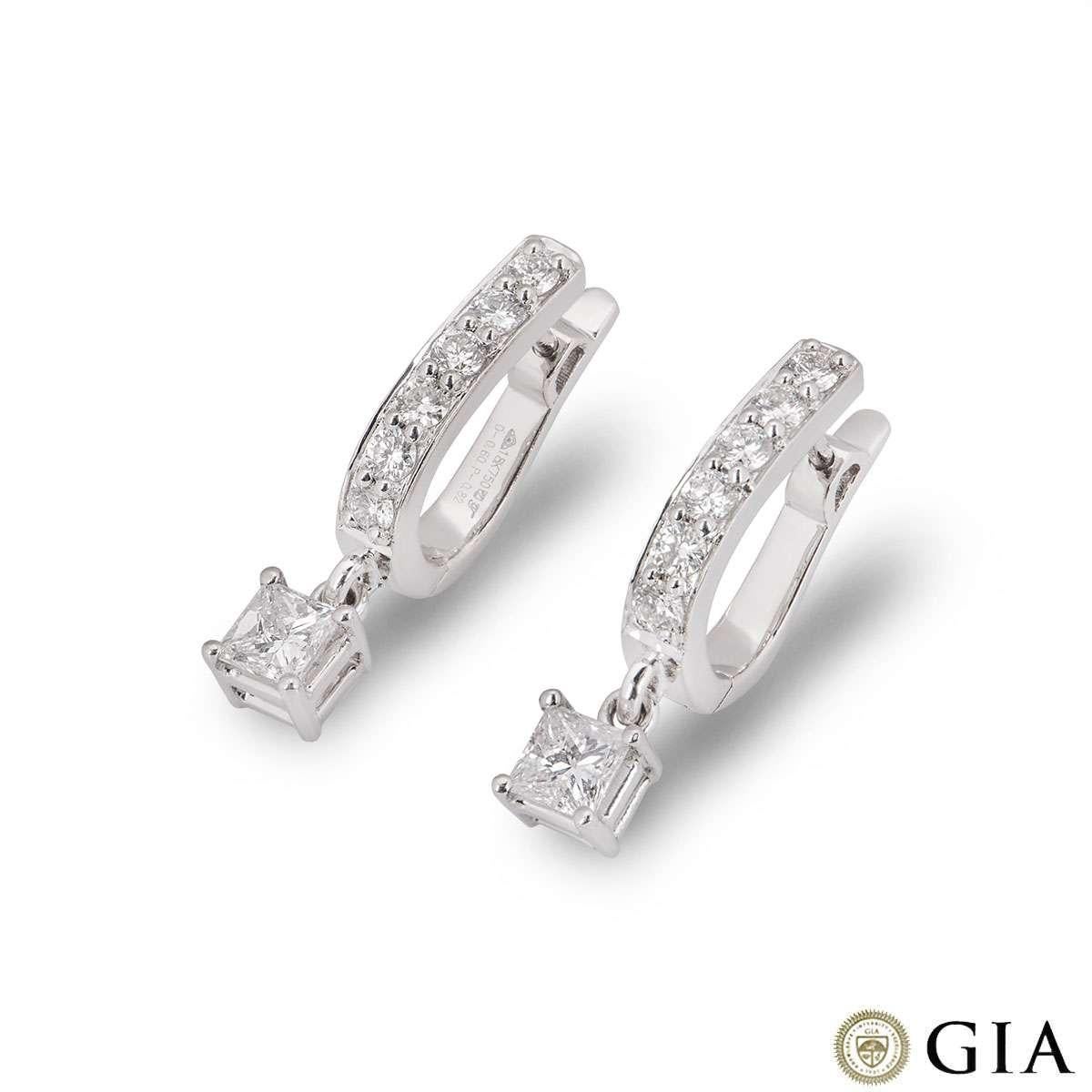 A pair of 18k white gold diamond drop earrings. The earrings each feature a hoop half set with 6 round brilliant cut diamonds totalling 0.60ct. Suspended from the hoop is a single princess cut diamond in a freely moving 4 claw setting. Both diamonds