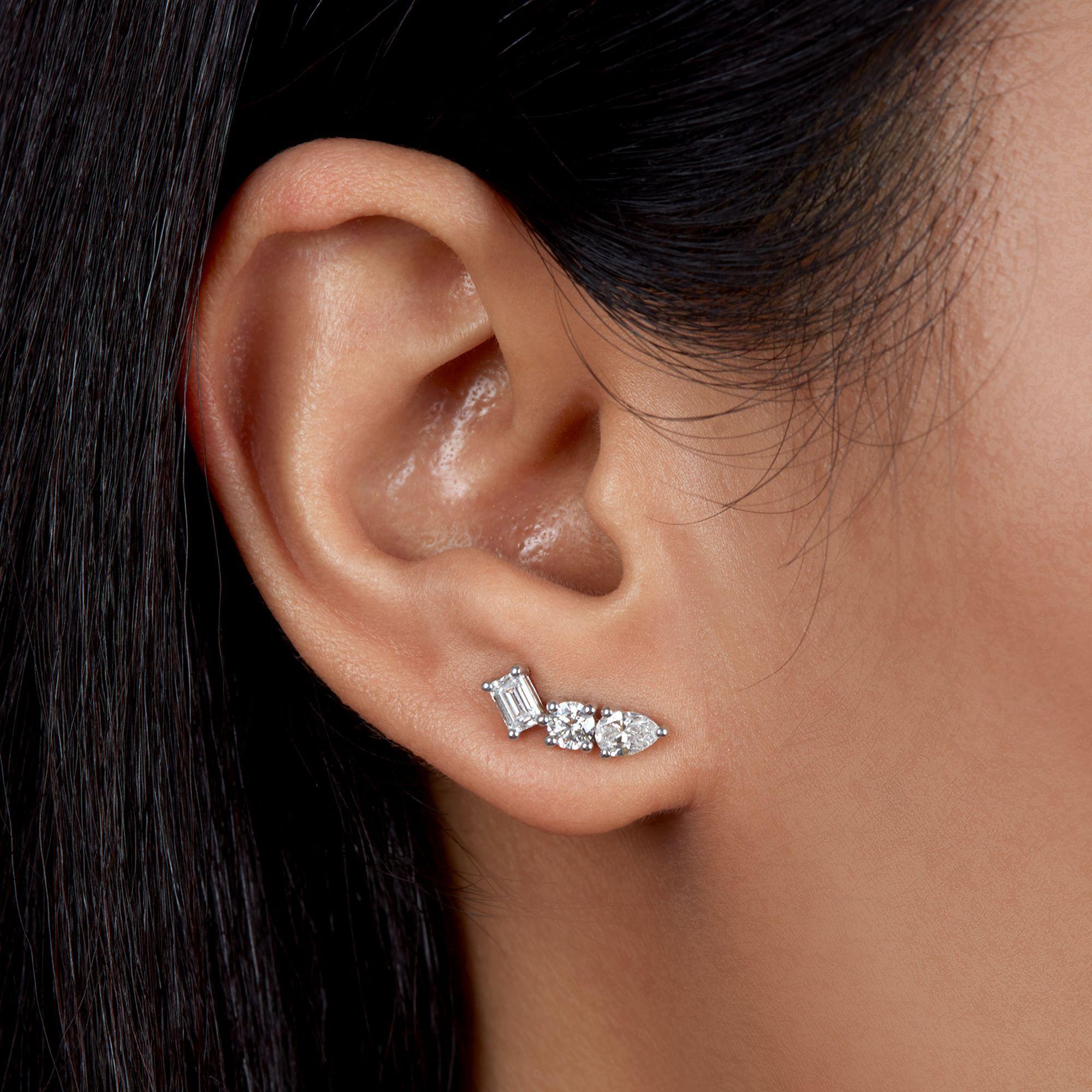 These 1ctw diamond earrings feature pear, round, and emerald-cut stones arranged in a smooth upward curve. Each diamond is spaced to highlight its shape and sparkle. Designed and made in New York, they sit neatly along the ear for a clean, modern