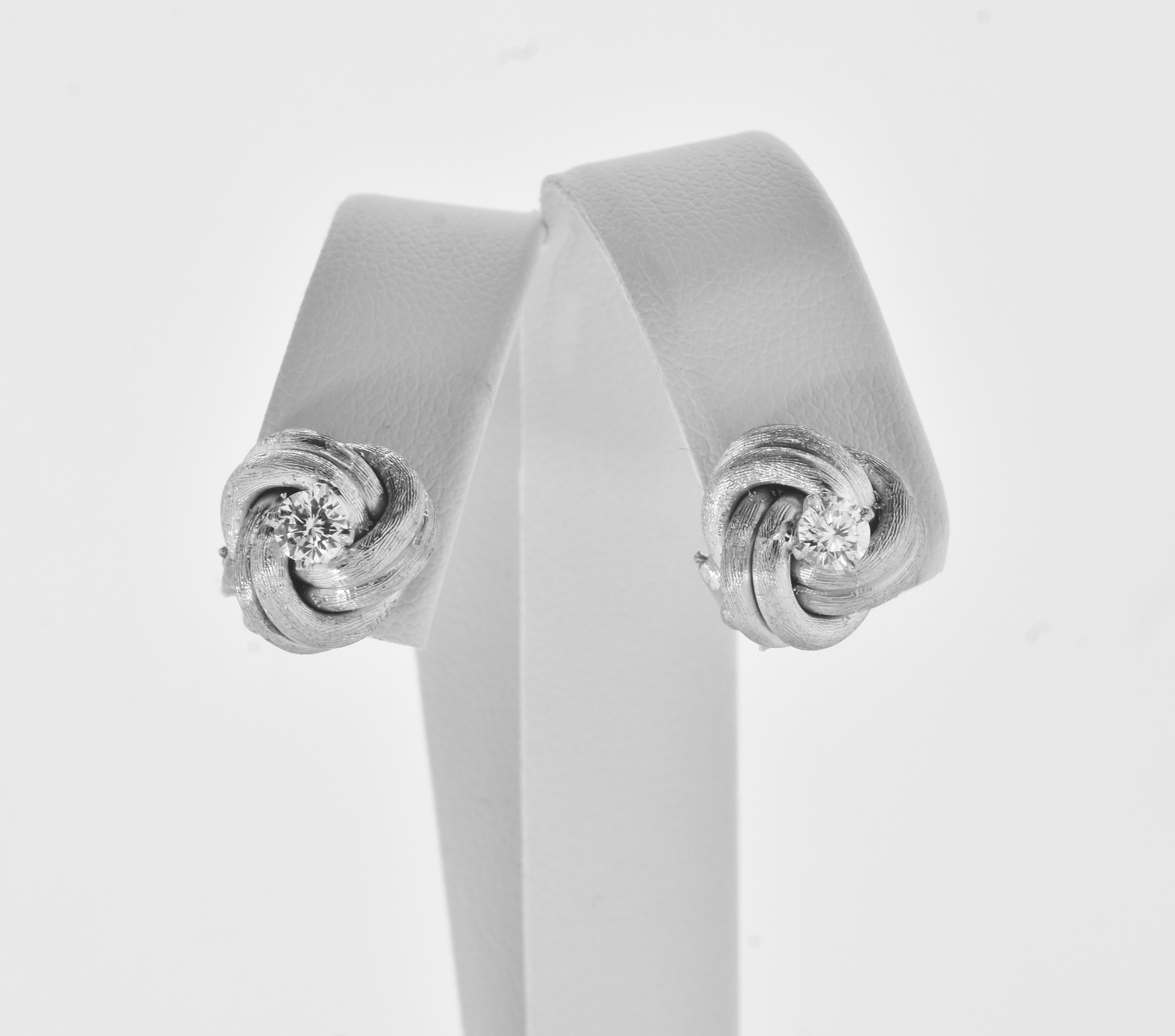 Diamond earrings, in the form of a cunning diamond love knot.  These earrings are perfect in a twisted white gold knot centering a fine prong set white brilliant cut diamond.  Each diamond is estimated to weigh, by our internal gemologist, .25 cts. 