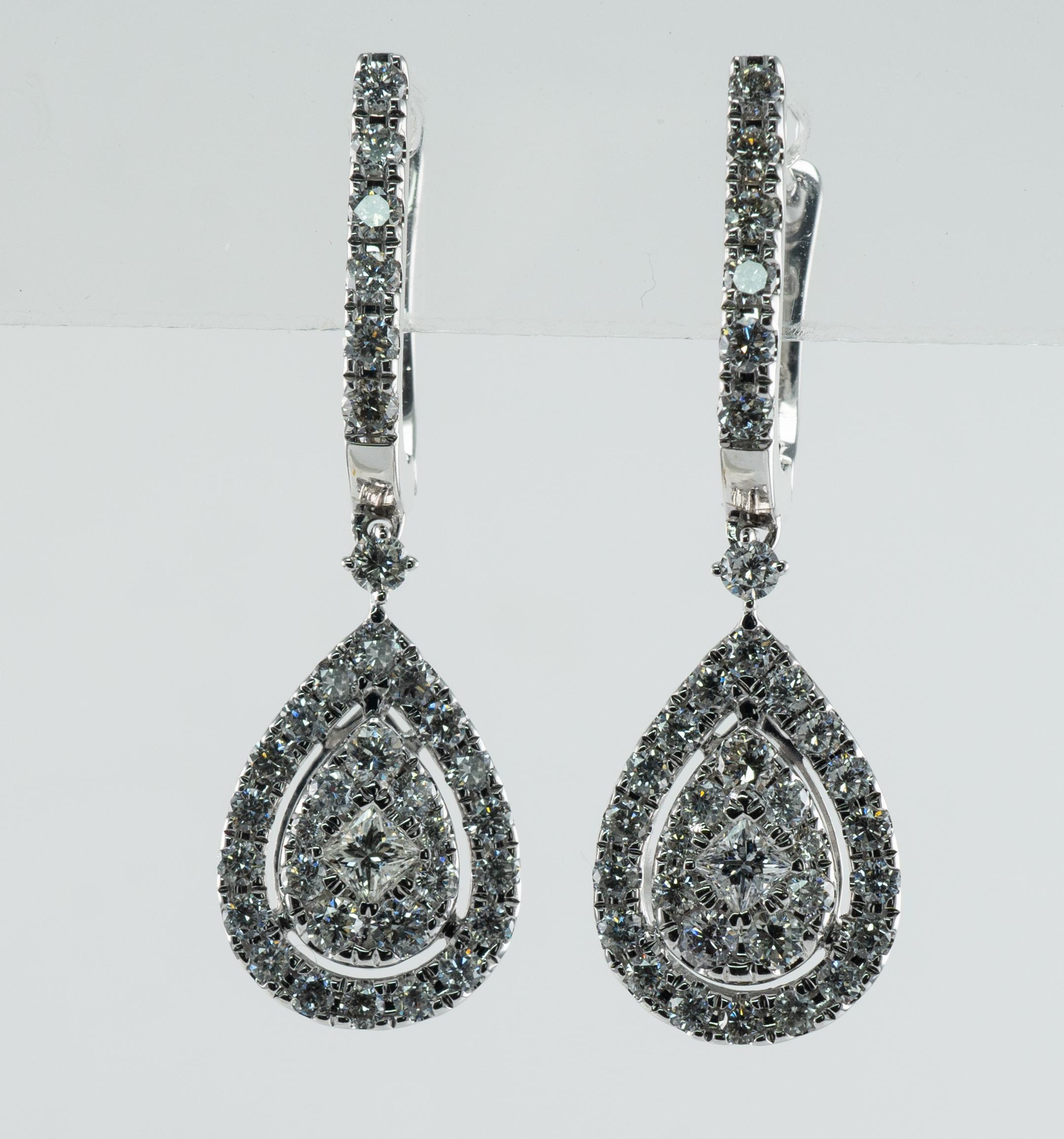 Diamond Earrings 14K White Gold Dangle 1.82 TDW Teardrop Shape

These estate earrings are made in solid 14K White Gold.
The center square diamond is .08 carat.
34 Round brilliant cut in each earring total .83 carat.
The total diamond weight for the
