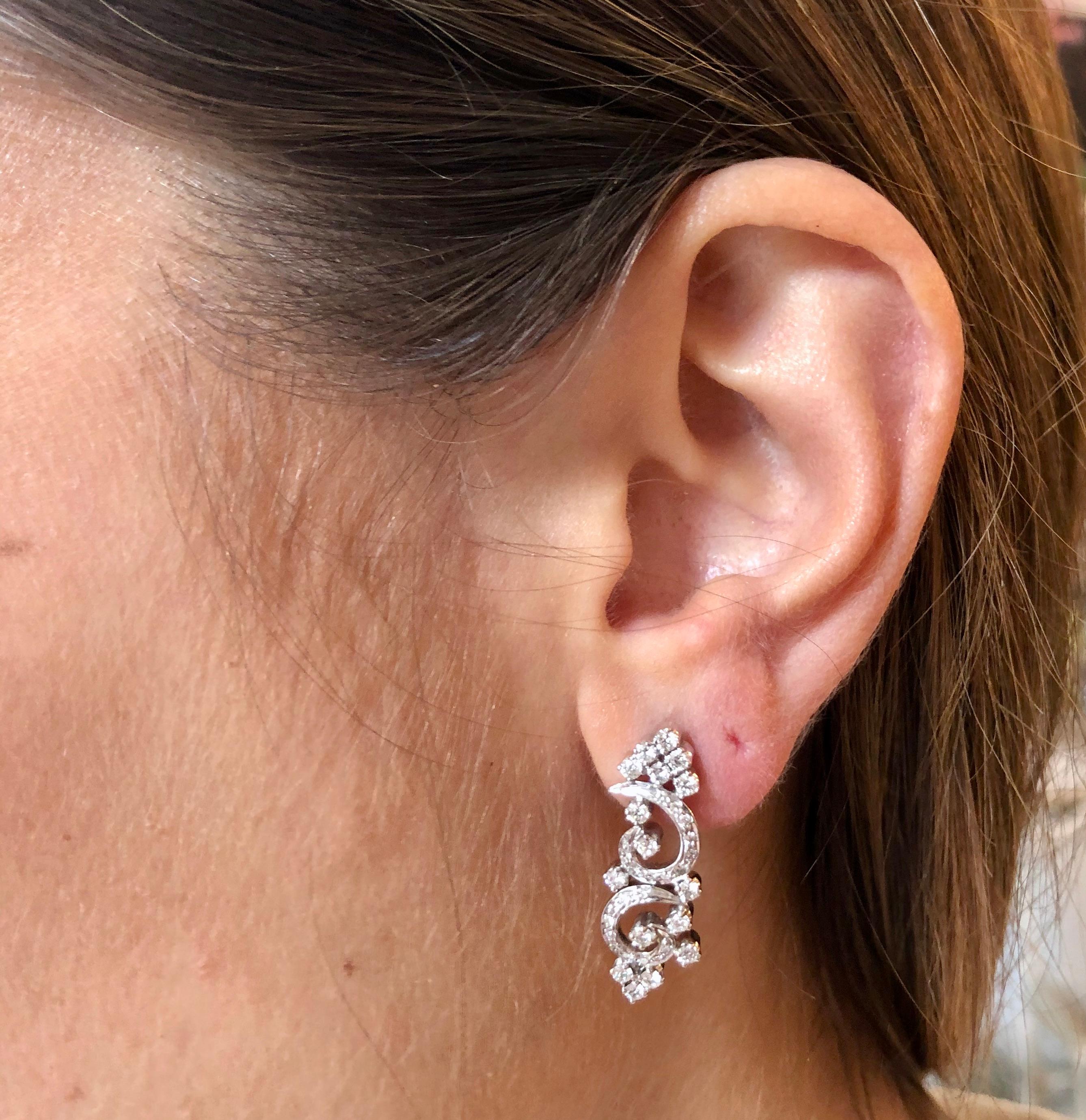 Art Deco style Diamond double scroll earrings set with a myriad of brilliant cut diamonds set in 18k white gold.
Post and butterfly fittings. 

The earrings are gracefully proportioned. Each earring features a fine articulation which allows the