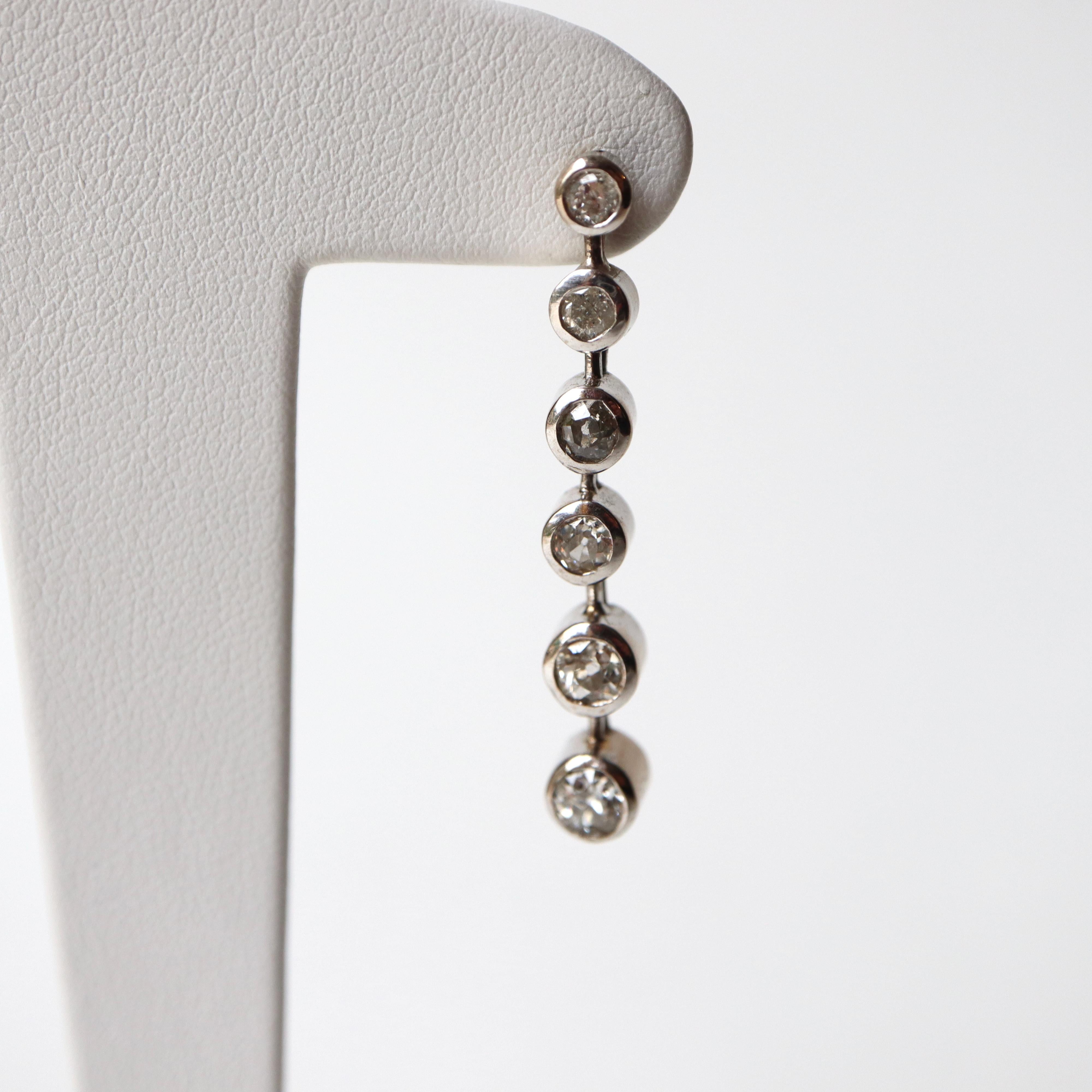 Boucles d'oreilles pendantes en or blanc 18 carats et diamants
Chaque boucle d'oreille contient 6 diamants sertis en chaton de tailles et de qualités différentes, pour un poids total d'environ 1 carat de diamants par boucle d'oreille. Poids total
