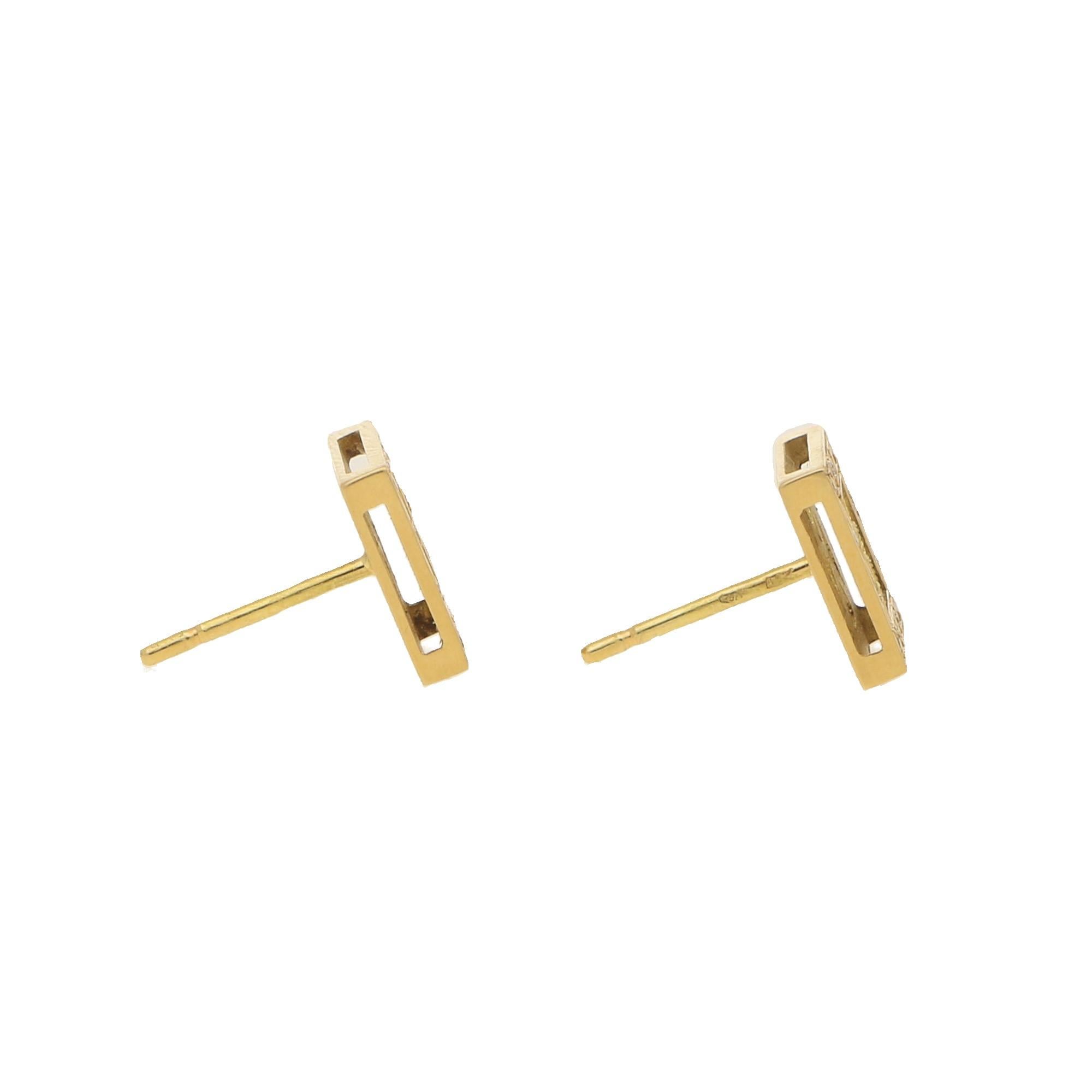 A pair of diamond filigree stud earrings in 18ct yellow gold. Each earring is composed of a squared surmount decorated with an openwork filigree floral spray to the centre. Within this is a yellow gold frame grain-set with 12 round brilliant-cut