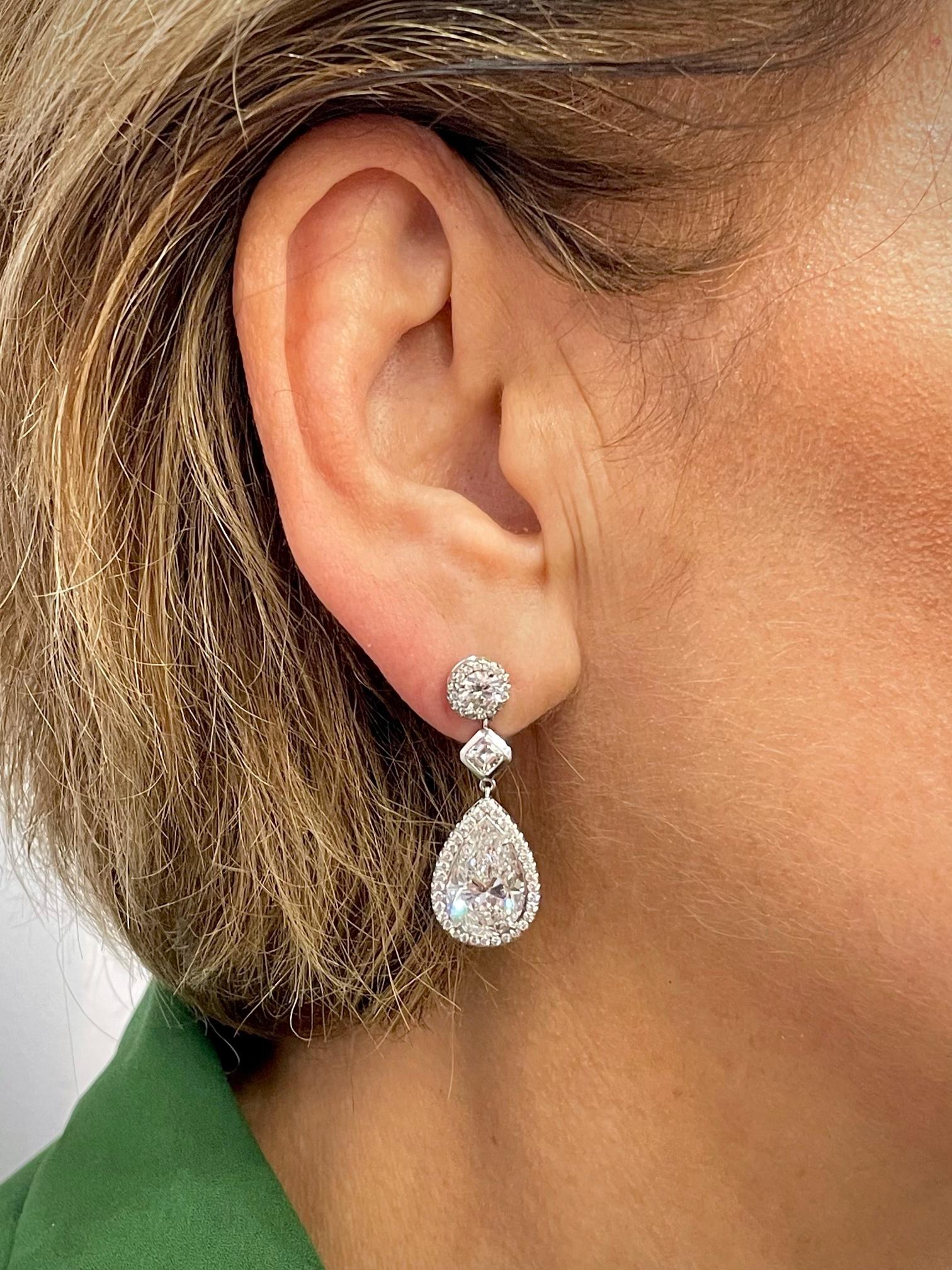 Impressive pair of pear shape diamond earrings suspending from a round diamond stud. Crafted by hand in 18K white gold.
The pear shapes weigh 5.10 carats F/SI2, and 5.06 carats E/SI1. 
The 2 round diamond studs weigh a total of 1.07 carats F/SI1.