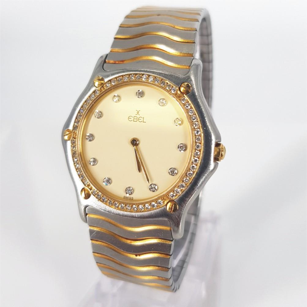 Diamond Ebel (Midsize) Ladies Watch - Battery in Very Good condition. 
Model Number: 181 949 & Serial Number: 13611630
Stainless Steel Case & 18ct Yellow Gold Bezel (33mm). Cream with Diamonds & Gold hands. Integrated Stainless Steel & 18ct Yellow