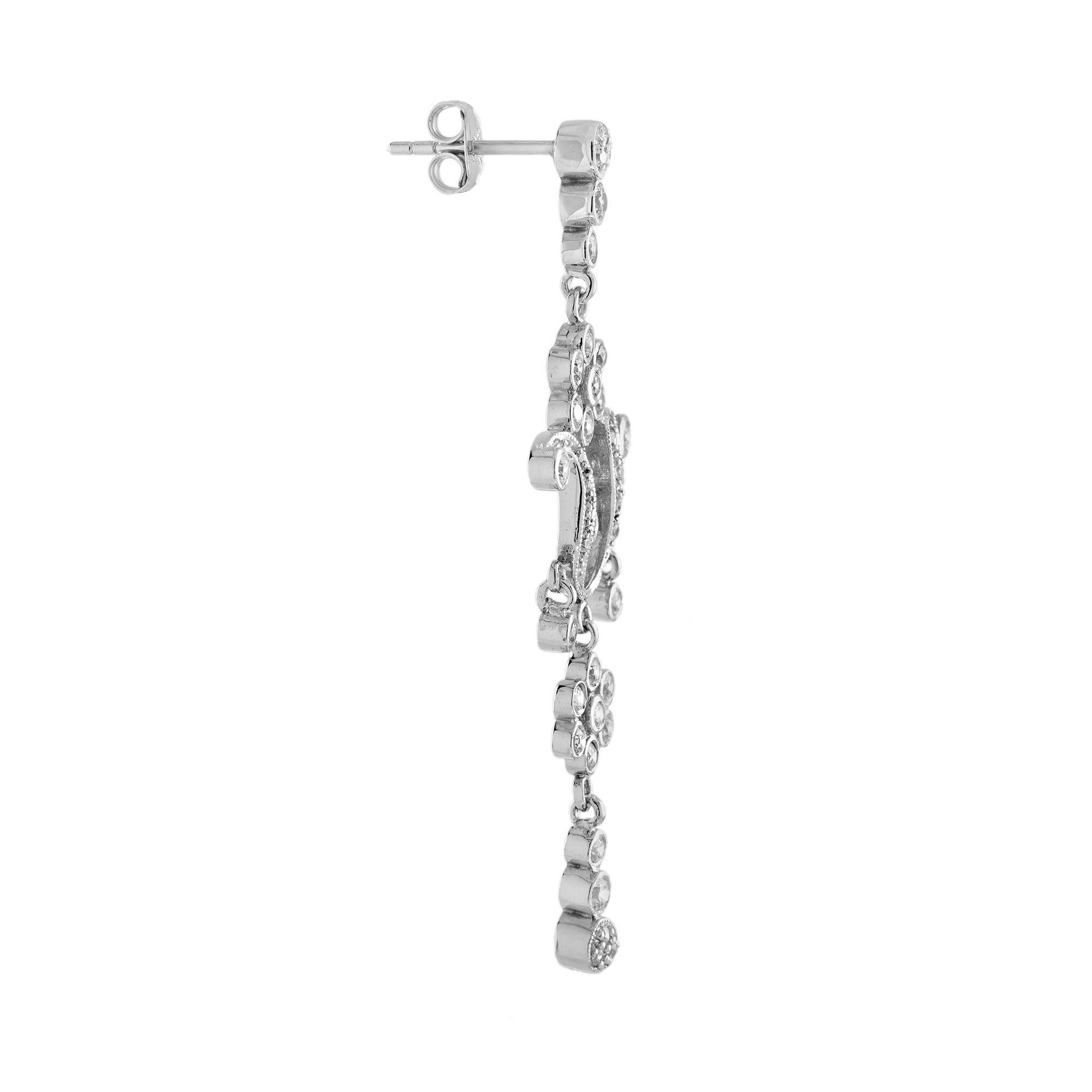A pair of delicate antique style dangle earrings is set with glittering round cut diamonds formed a floral cluster. Estimated total diamond weight is 1.2 carat. Ravishing, romantic, and ready for your ears. 14K White Gold. 
Earrings
