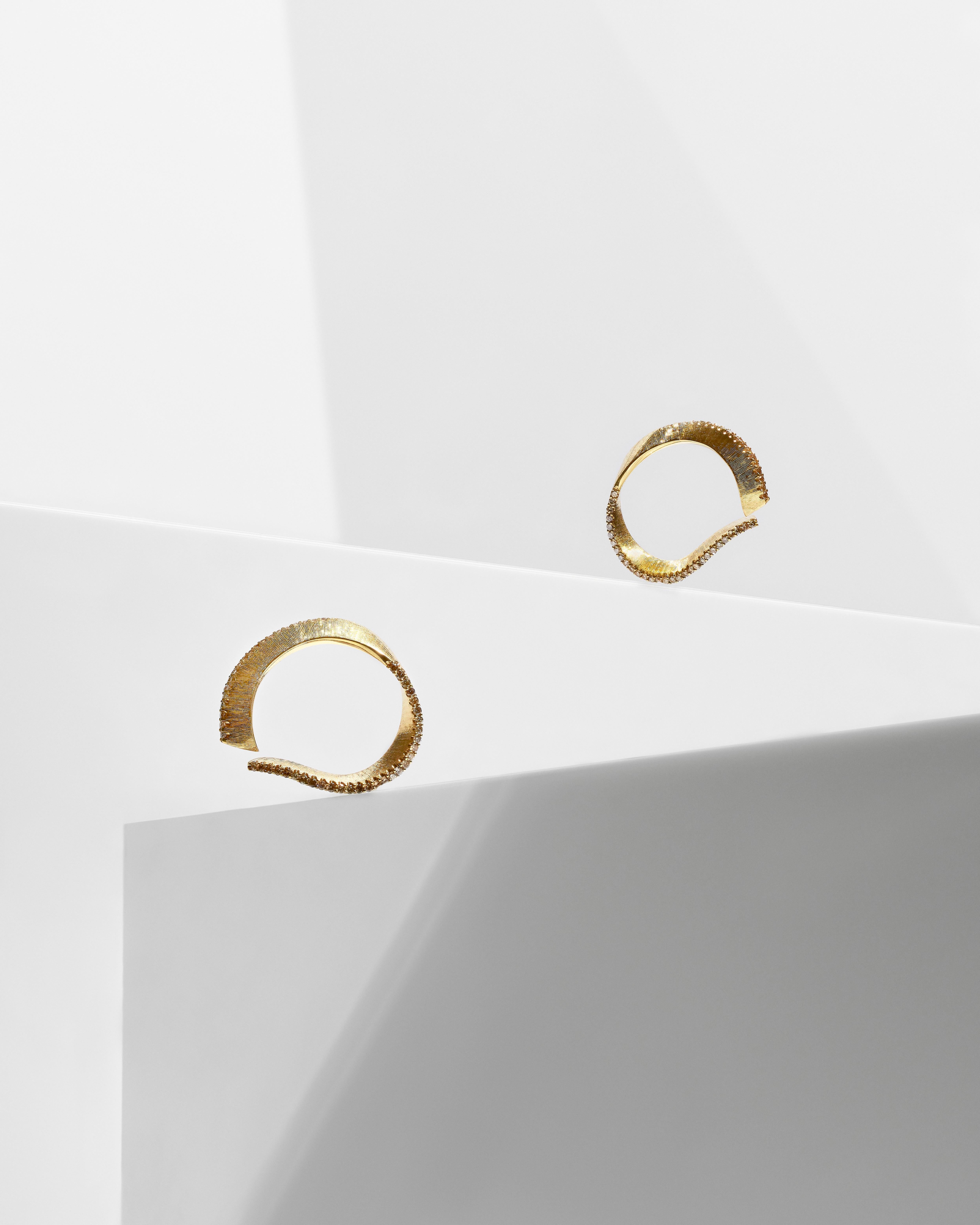 Liv Luttrell 
Diamond Edge Twist Hoop Earrings 2020
18-karat yellow gold 


Details
18-karat yellow gold 
Natural warm-tone diamonds
Silk engraving
Made in London 


Customisation 

As this design is handmade to your order, Liv is able to customise