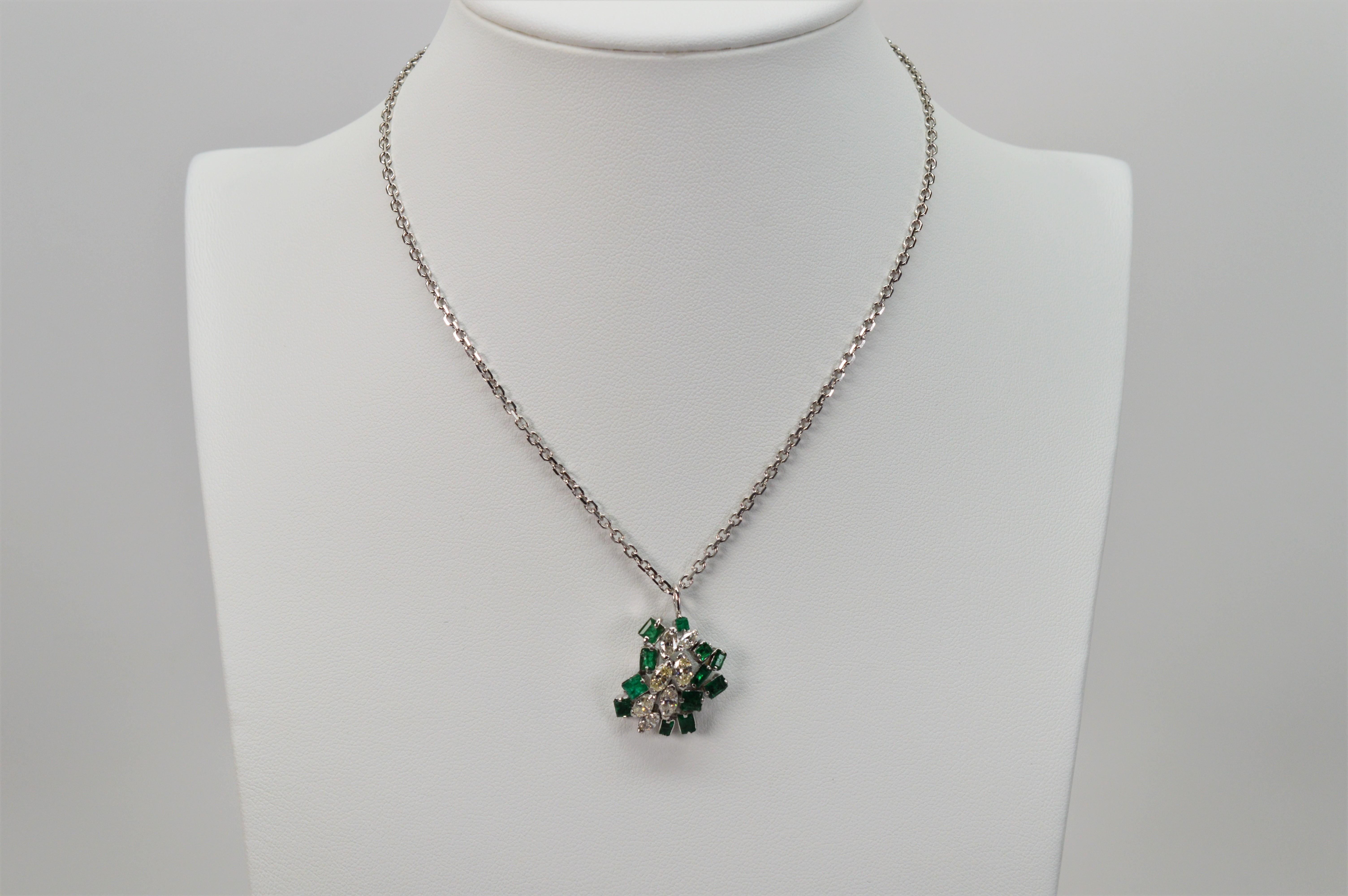 An eclectic bouquet of vivid green emeralds and bright diamonds create this abstract pendant necklace. Set in fourteen karat 14K white gold is an arrangement of mixed cuts consisting of seven marquise diamonds, .50 total weight and twelve natural