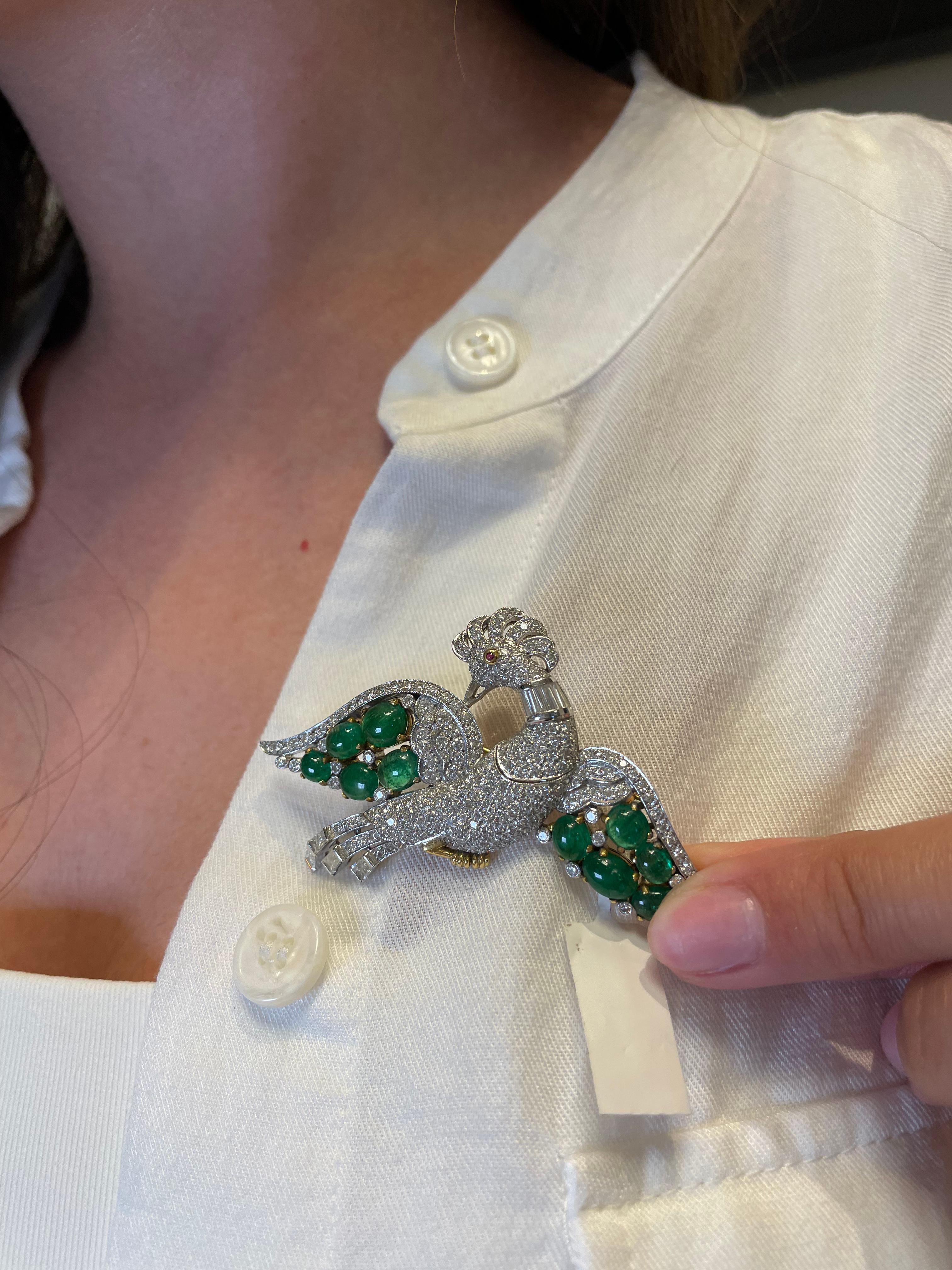 Vintage bird brooch with emeralds, diamonds, and ruby.
10 cabochon emeralds, approximately 5 carats. Round and baguette cut diamonds, approximately 3.50 carats, G/H color and VS2/SI1 clarity. 1 round ruby, approximately 0.03 carats. White and yellow