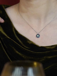 Collar con colgante en forma de diana con diamantes, esmeraldas y zafiros, en oro blanco de 18 quilates