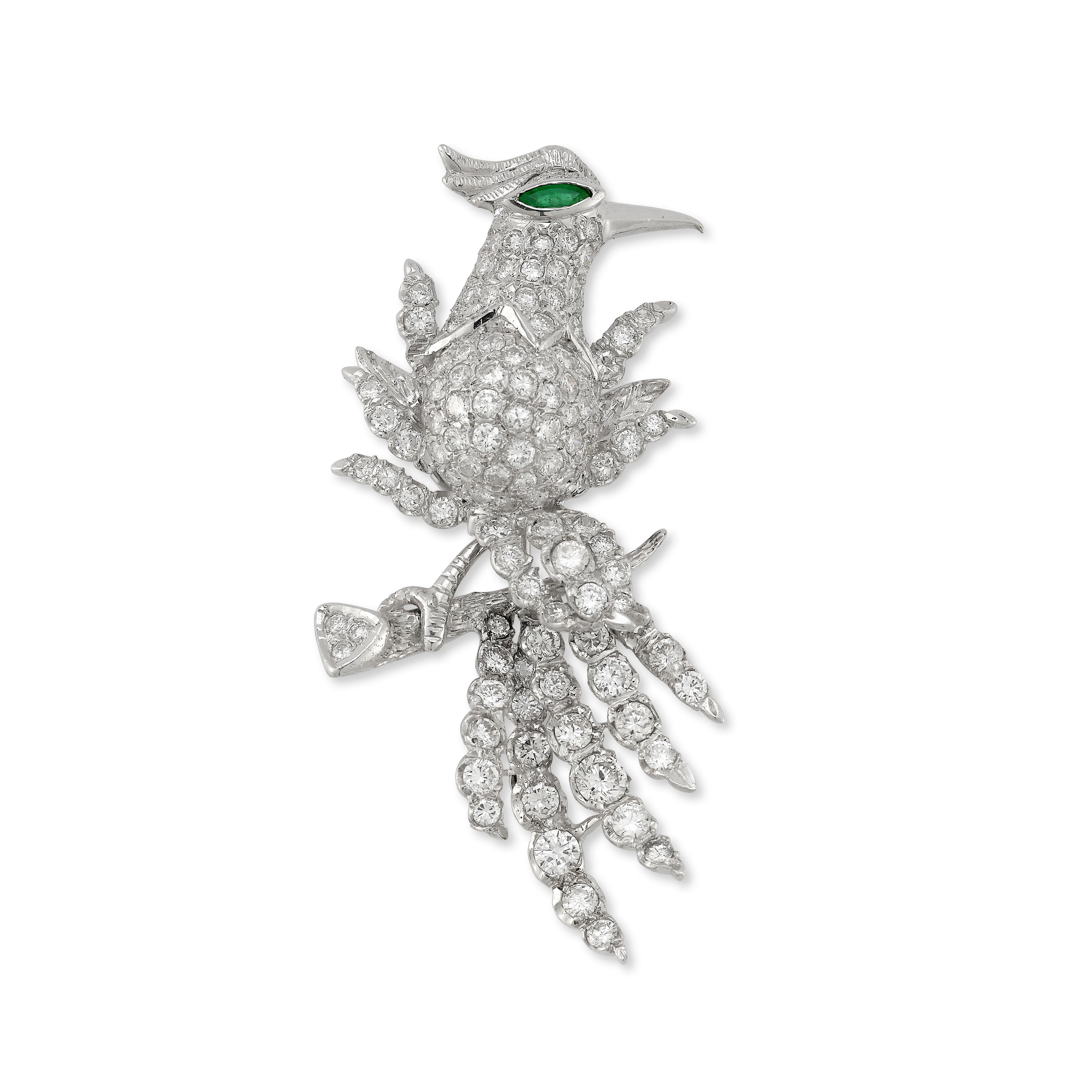 Diamond & Emerald Bird Brooch 

White gold brooch set with 113 round diamonds weighing approximately 7.28 carats in the shape of a bird of paradise with an emerald eye perched on a branch

Length: 2.63 in

14 karat gold