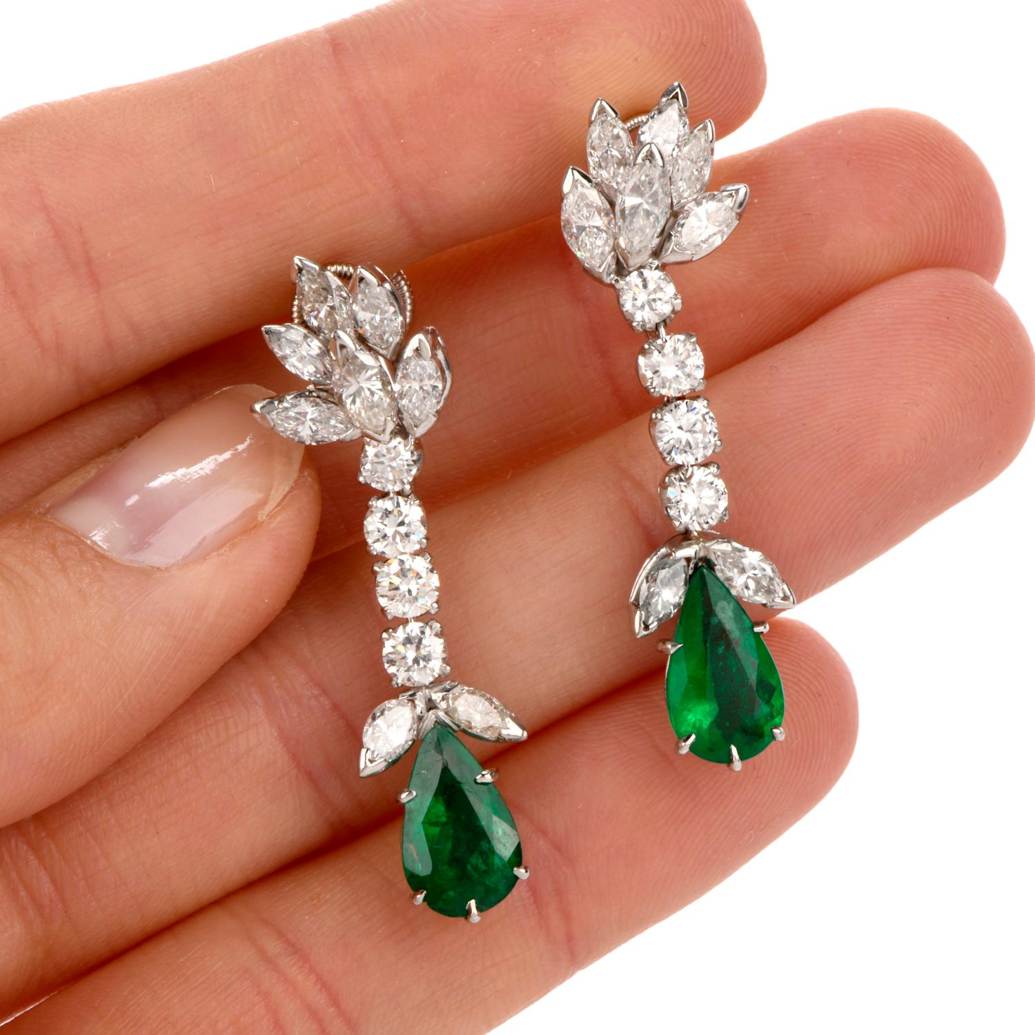 These elegant diamond and emerald drop earrings are crafted in solid platinum, weighing 10.6 grams and measuring 42mm long x 11mm wide. Displaying a botanically inspired array of diamonds, prong-set with 16 marquise-shape diamonds, weighing