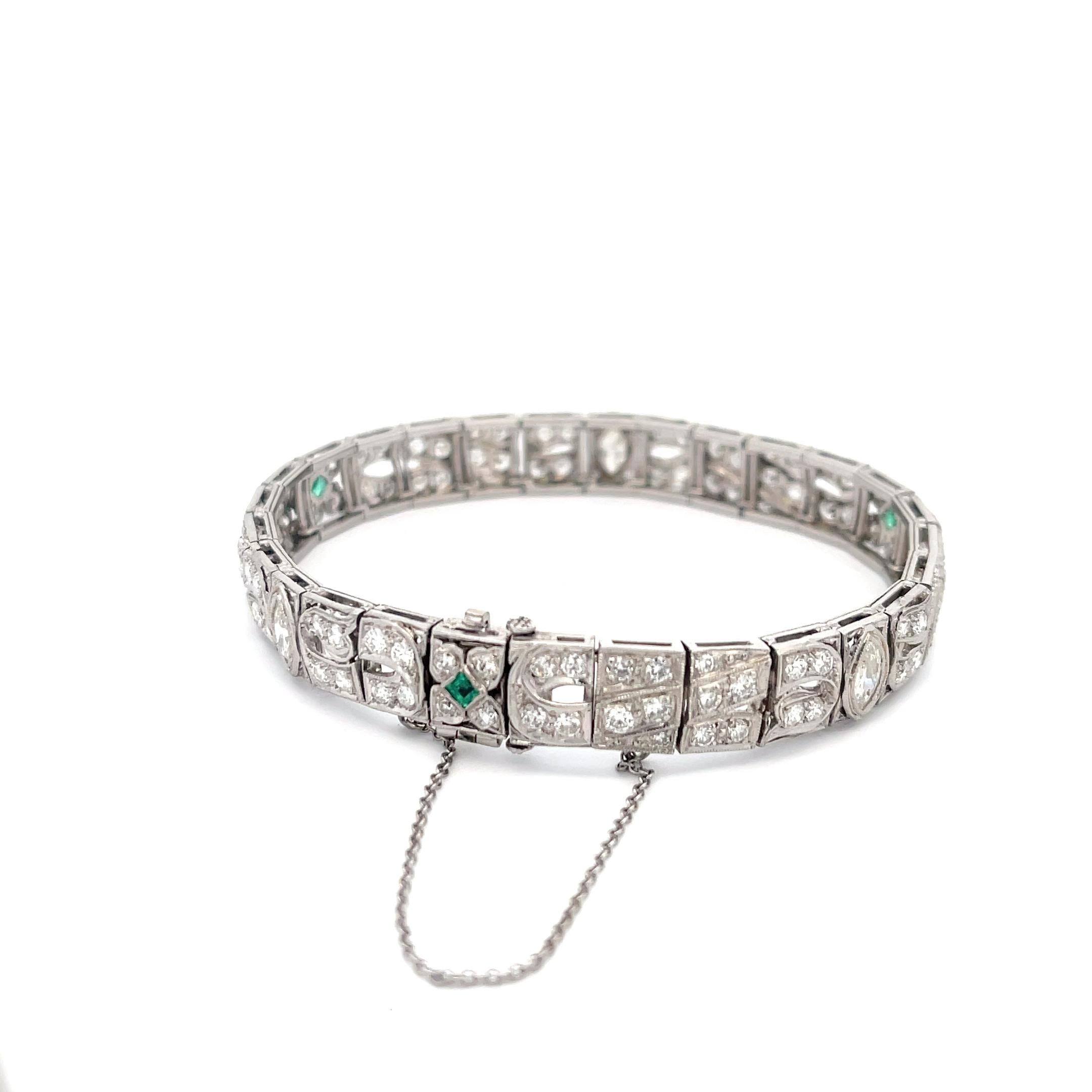 Diamond and Emerald Bracelet in Platinum. The bracelet features 1.08ctw of round and marquise diamonds and 0.12ctw of square cut emeralds. The bracelet is 7 inches long, 8.6mm wide, and weighs 30.3 grams.