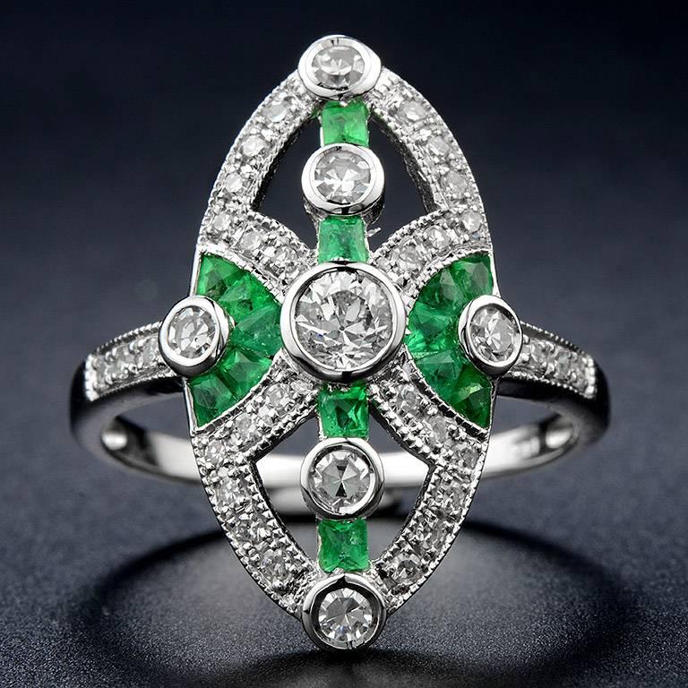 Center set with Old Cut Diamond 0.17 Carat in the center with Single Cut Diamond 6 pieces 0.23 Carat. Outlined and set on the shoulders with small Single Cut Diamond 30 pieces 0.18 Carat. High-lighted by French Cut Zambian Emerald total 14 pieces