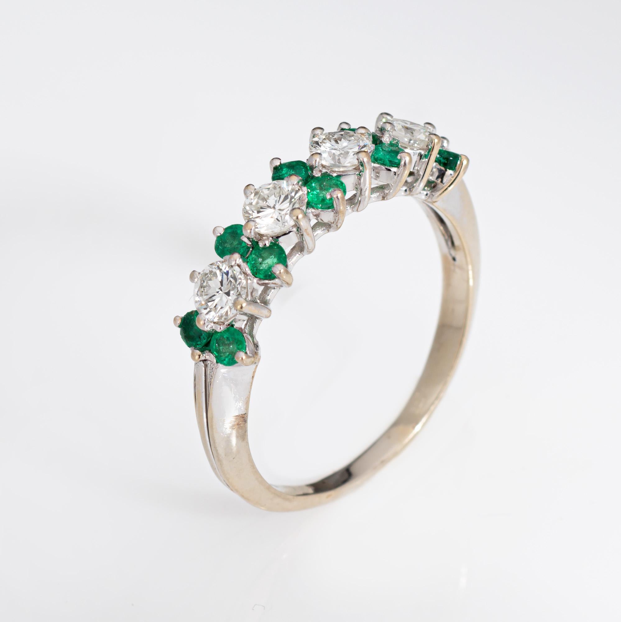 Stylish and finely detailed diamond & emerald ring crafted in 18 karat white gold.

Four diamonds total an estimated 0.60 carats (estimated at H-I color and VS2-SI1 clarity). Emeralds measure approx. 2mm each. The emeralds are in good condition and