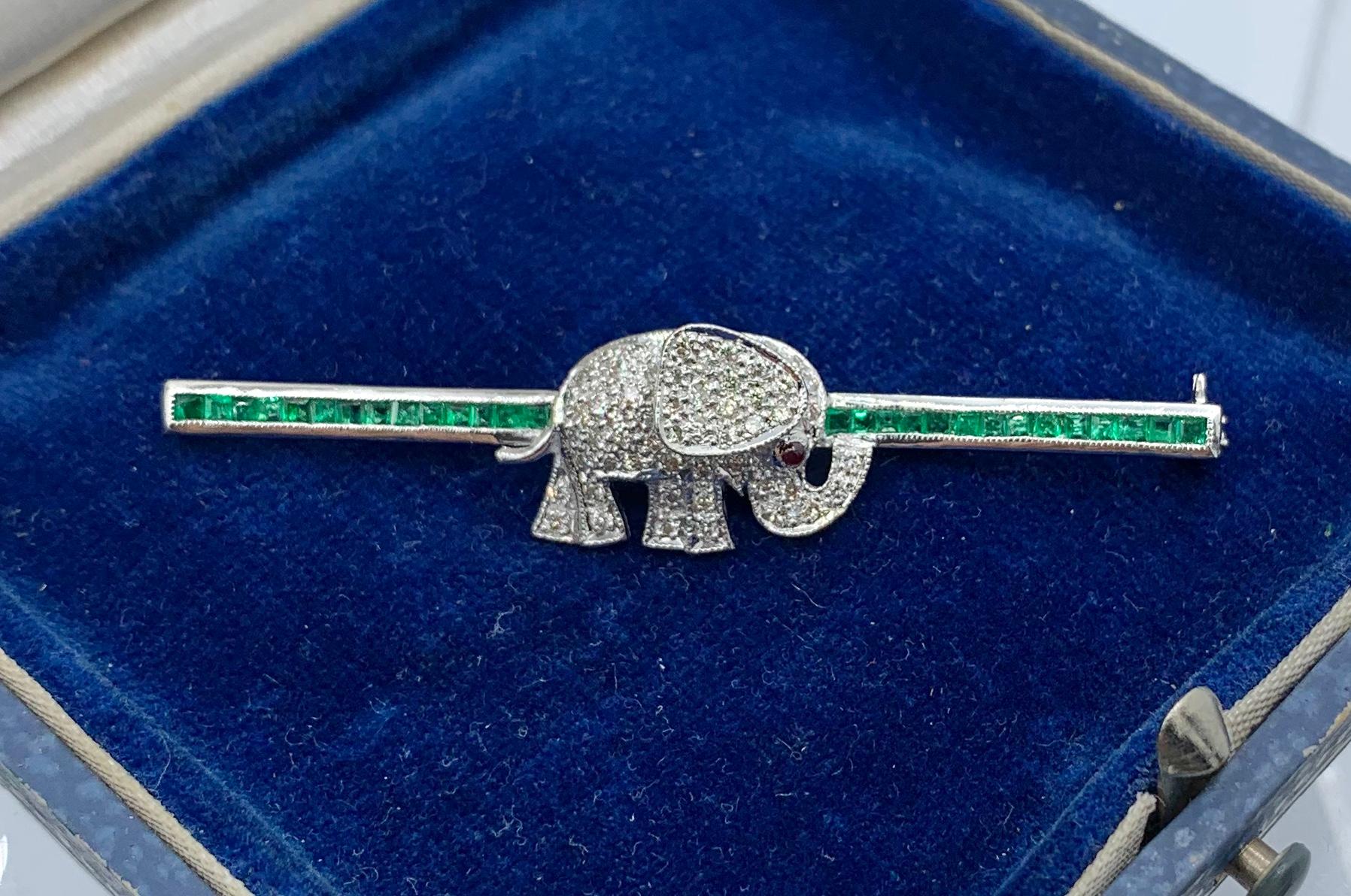 This is a fabulous vintage Retro Elephant Diamond Emerald Ruby Brooch Pin in 18 Karat White Gold.  The wonderful elephant brooch is absolutely charming!  The elephant is set throughout with pave set diamonds.  The diamonds are of superb quality and
