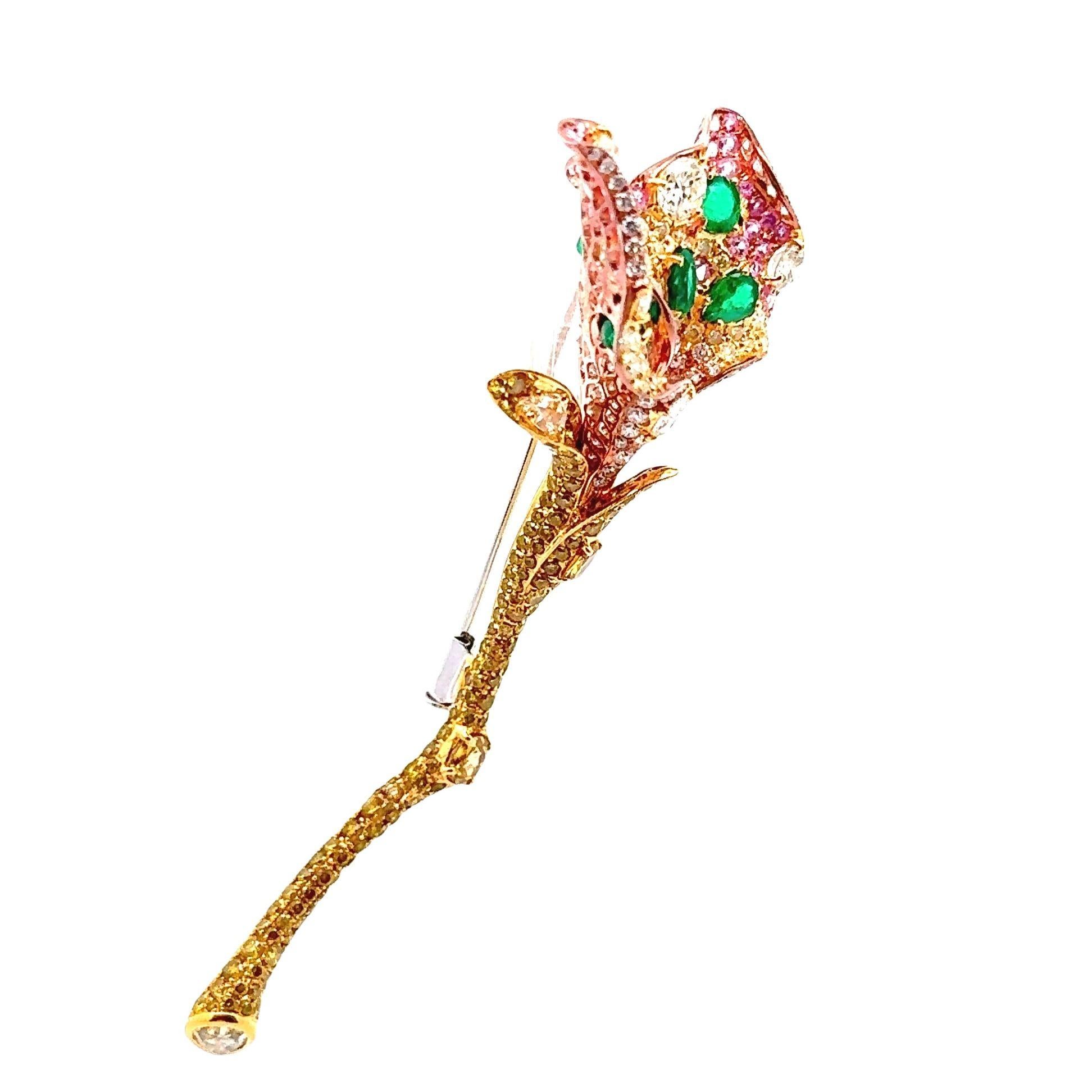 An intricate and highly detailed floral brooch featuring a plethora of fine gemstones. The brooch features 5 vivid bright green emeralds which have rich intense color, and weigh a total of 1.20 carats. Adding to that are round pink sapphires set