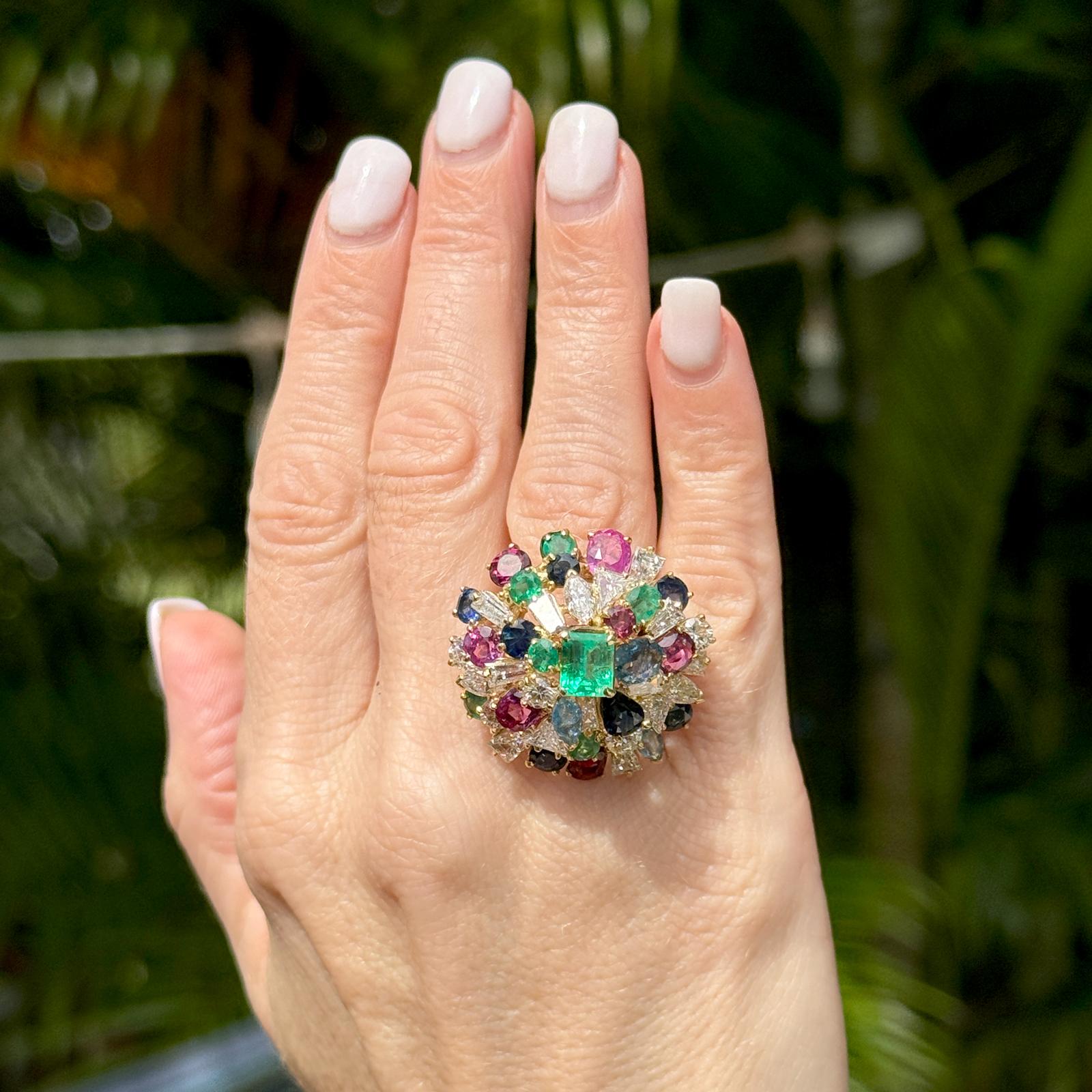 Fabulous Tutti Frutti diamond and colorful precious gemstone ring handcrafted in 18 karat yellow gold. The ring features 18 diamonds weighing approximately 4.00 carat total weight, an 1.50 carat emerald cut emerald and approximately 6.00 CTW ruby,
