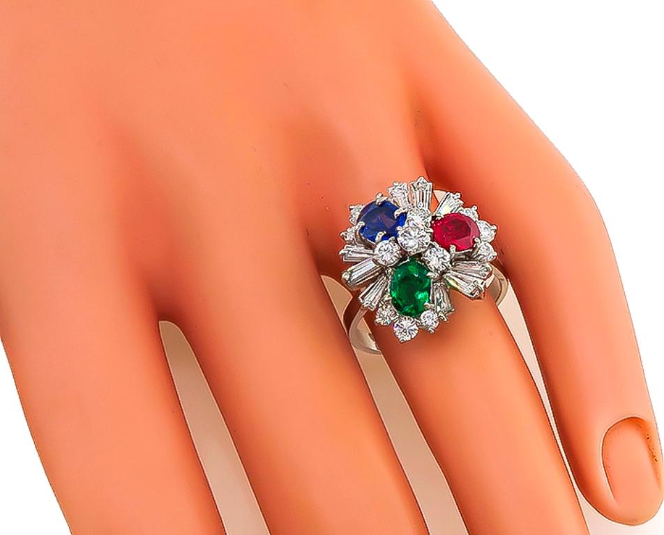 This gorgeous 18k white gold ring is set with lovely oval cut Colombian emerald, sapphire and ruby that weighs approximately 0.50ct, 0.80ct and 0.80ct respectively. The colored stones are accentuated by sparkling round and baguette cut diamonds that
