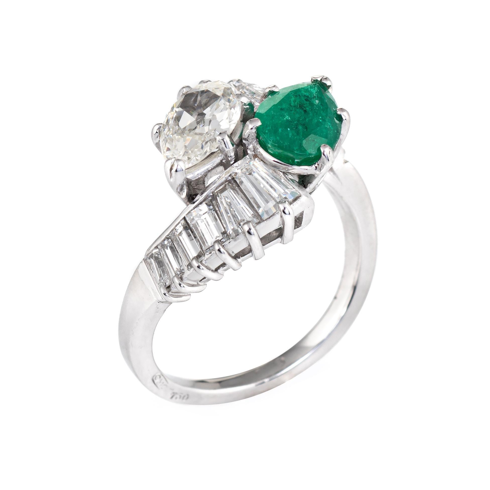 Elegant vintage emerald & diamond bypass ring (circa 1950s to 1960s) crafted in 18 karat white gold. 

Centrally mounted old pear cut diamond measures 7.5mm x 5.5mm (estimated at 1 carat). The diamond is estimated at J-K color and VS2-SI1 clarity.
