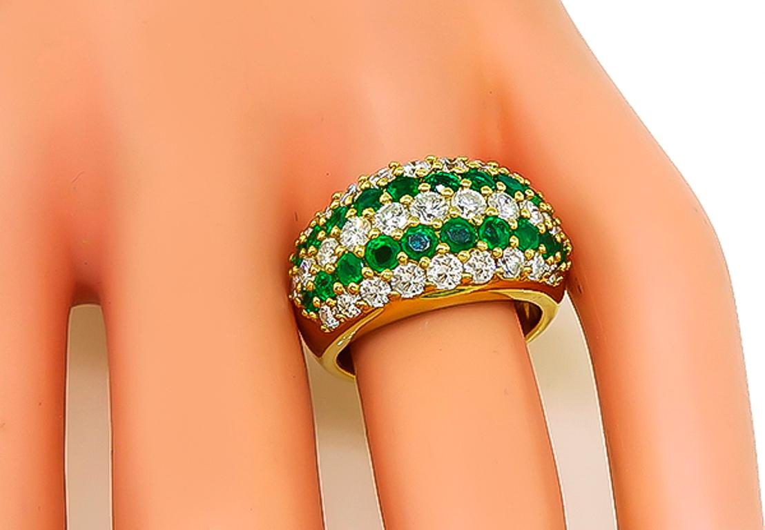 This charming 18k yellow gold ring is set with sparkling round cut diamonds that weigh 1.72ct graded G color with VS clarity. Accentuating the diamonds are high qality emeralds that weigh 1.14ct. The ring has a tapering width from 5mm to 12mm. The