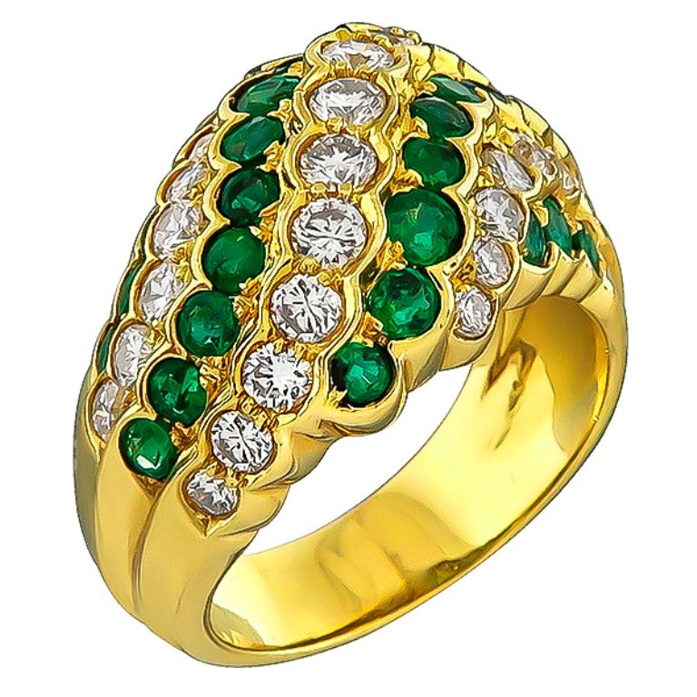Made of 18k yellow gold, this ring is set with sparkling round cut diamonds that weigh 1.03ct graded F-G color with vs clarity. Accentuating the diamonds are high quality emeralds that weigh 1.04ct. The top of the ring measures 13mm by 21mm. The