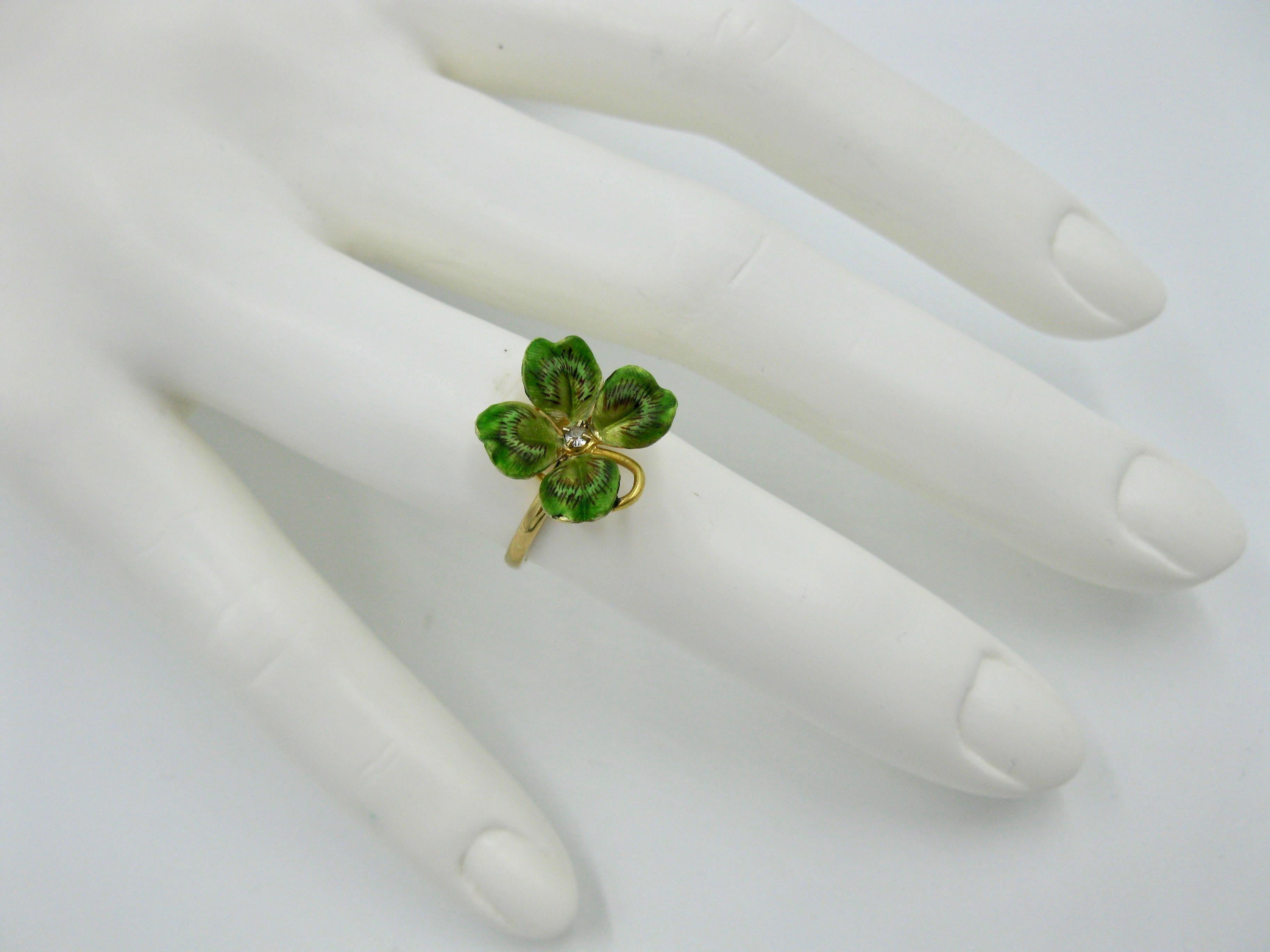 A very special Victorian - Edwardian Ring in the form of a four leaf clover or shamrock.  The beautiful flower is done with exquisite enamel work in various shades of green with black highlights.  In the center of the leaves is a diamond.  The gold