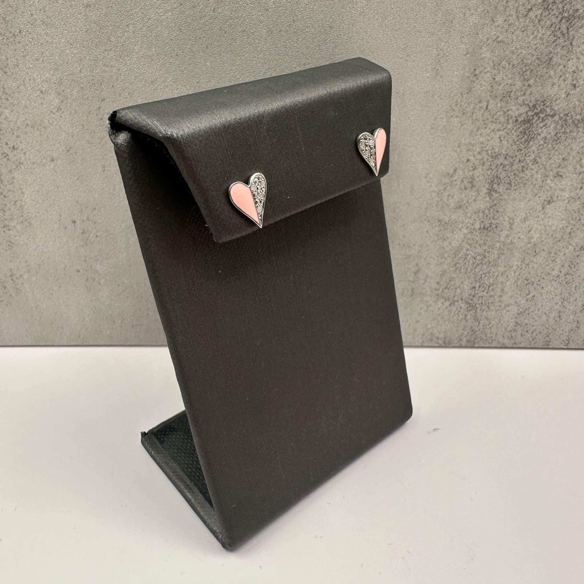 These charming Diamond & Enamel Heart Studs in Sterling Silver feature a 0.04 carat total weight (ctw) of natural I color, I clarity round diamonds, set against a vibrant pink enamel heart design. Measuring 9.2mm in height, these earrings add a