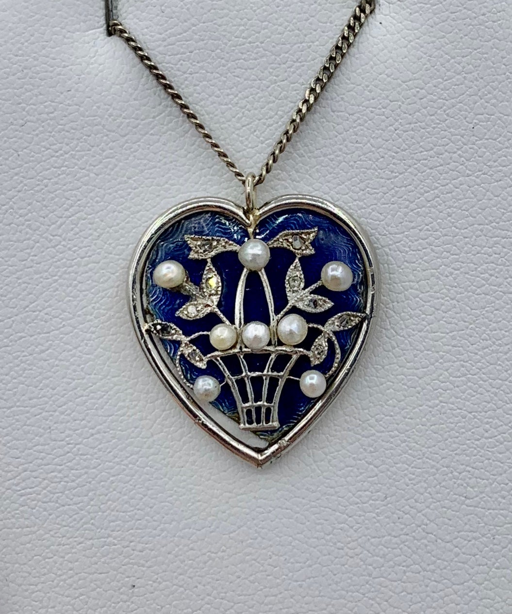 THIS IS AN EXTRAORDINARY MUSEUM QUALITY ANTIQUE VICTORIAN - EDWARDIAN PENDANT NECKLACE.  THE PENDANT IS IN THE FORM OF A HEART WITH A FLOWER BASKET IN 14K WHITE GOLD WITH ROSE CUT DIAMONDS AND PEARLS IN AN OPENWORK DESIGN ON A ROYAL BLUE ENAMEL