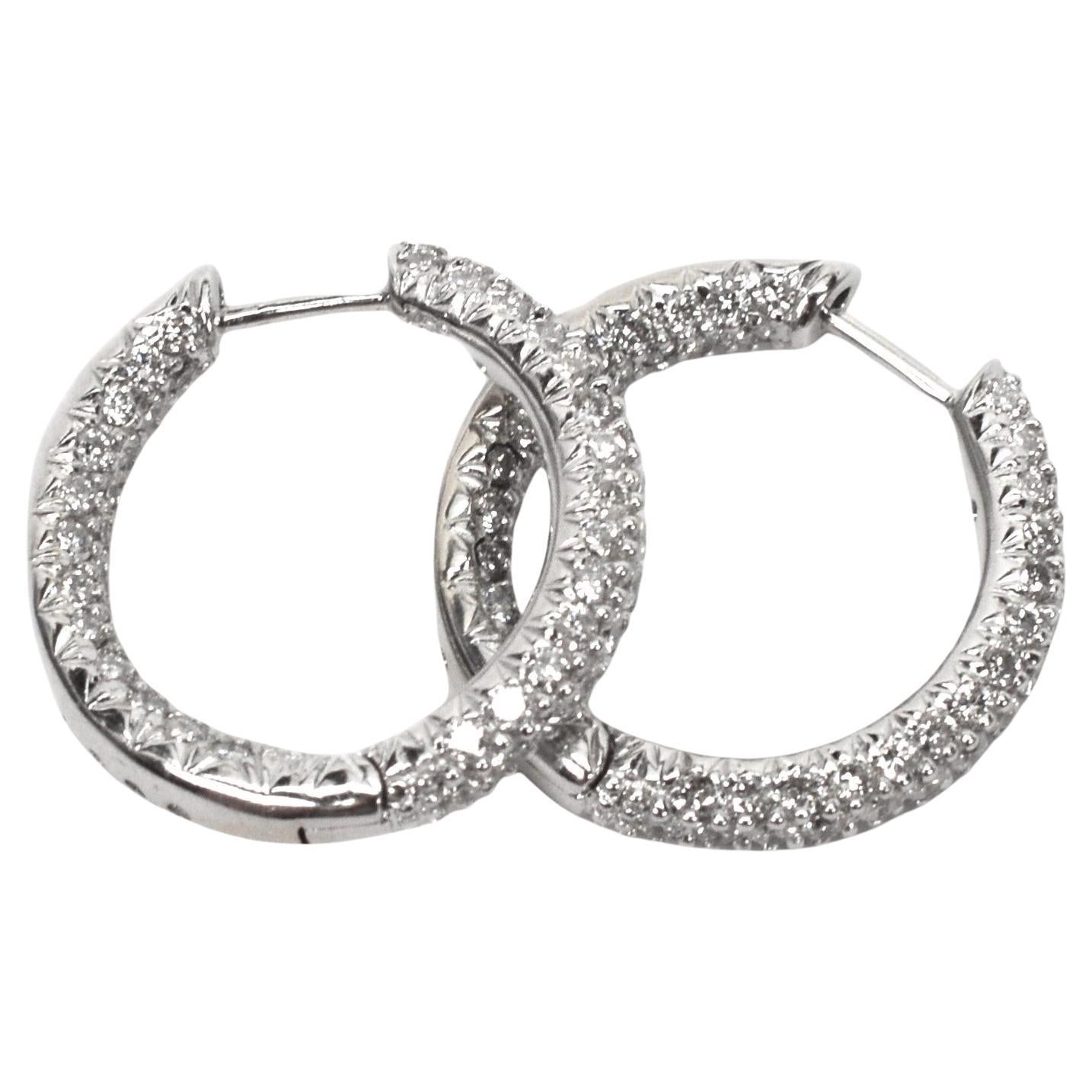 High sparkle and encrusted with over one carat of H/VS round faceted diamonds individually prong set in 18 karat white gold create this stunning round 20mm hoop earring pair (approx. 3/4 inch diameter) . Expertly crafted, the front face of the 18
