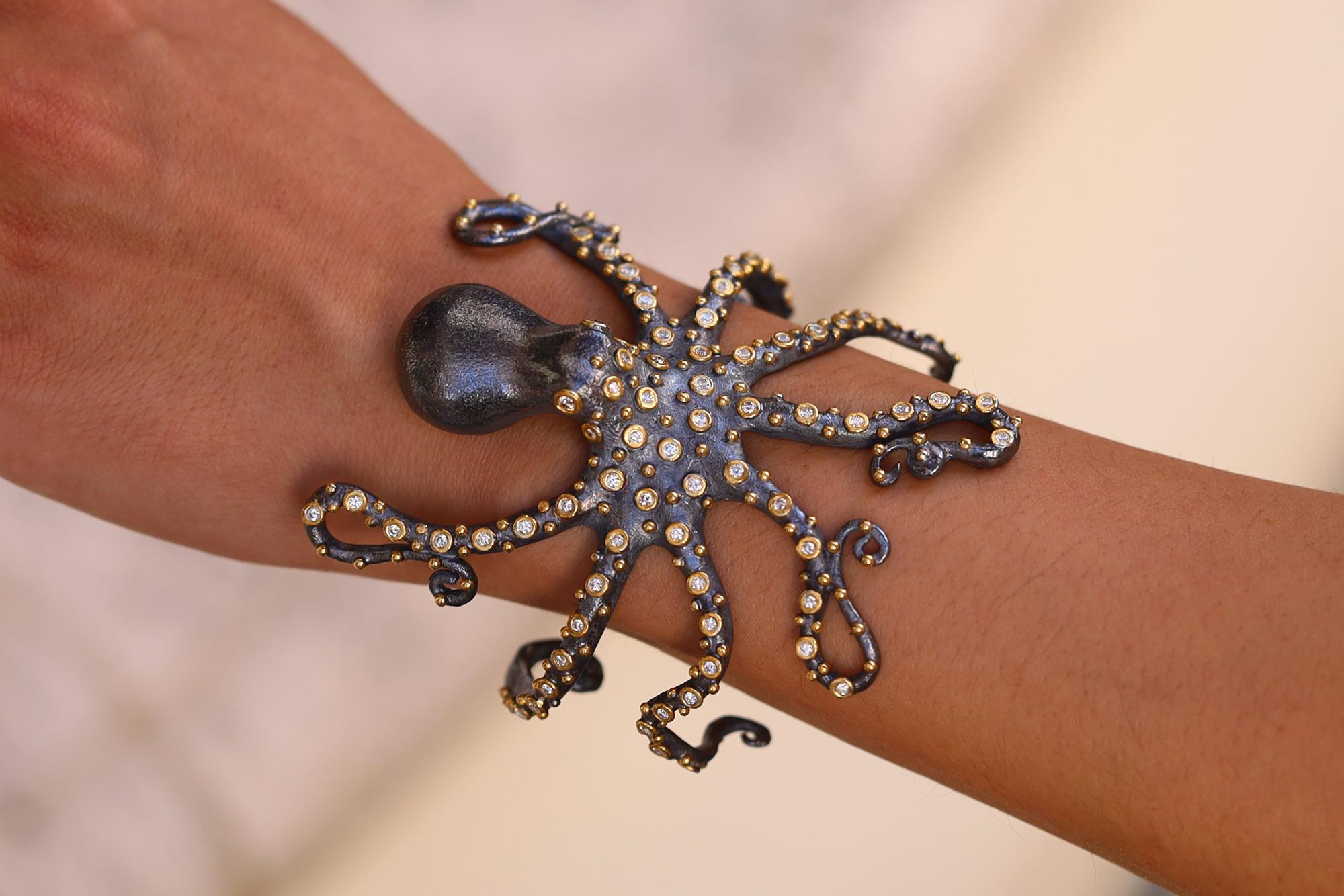 This outstanding octopus cuff bracelet adorned with diamond tentacles is artfully rendered in rich 24k gold and oxidized sterling silver 2 tone. Wrapping seductively around the wrist, this sea-life creature has piercing colorless diamond eyes and