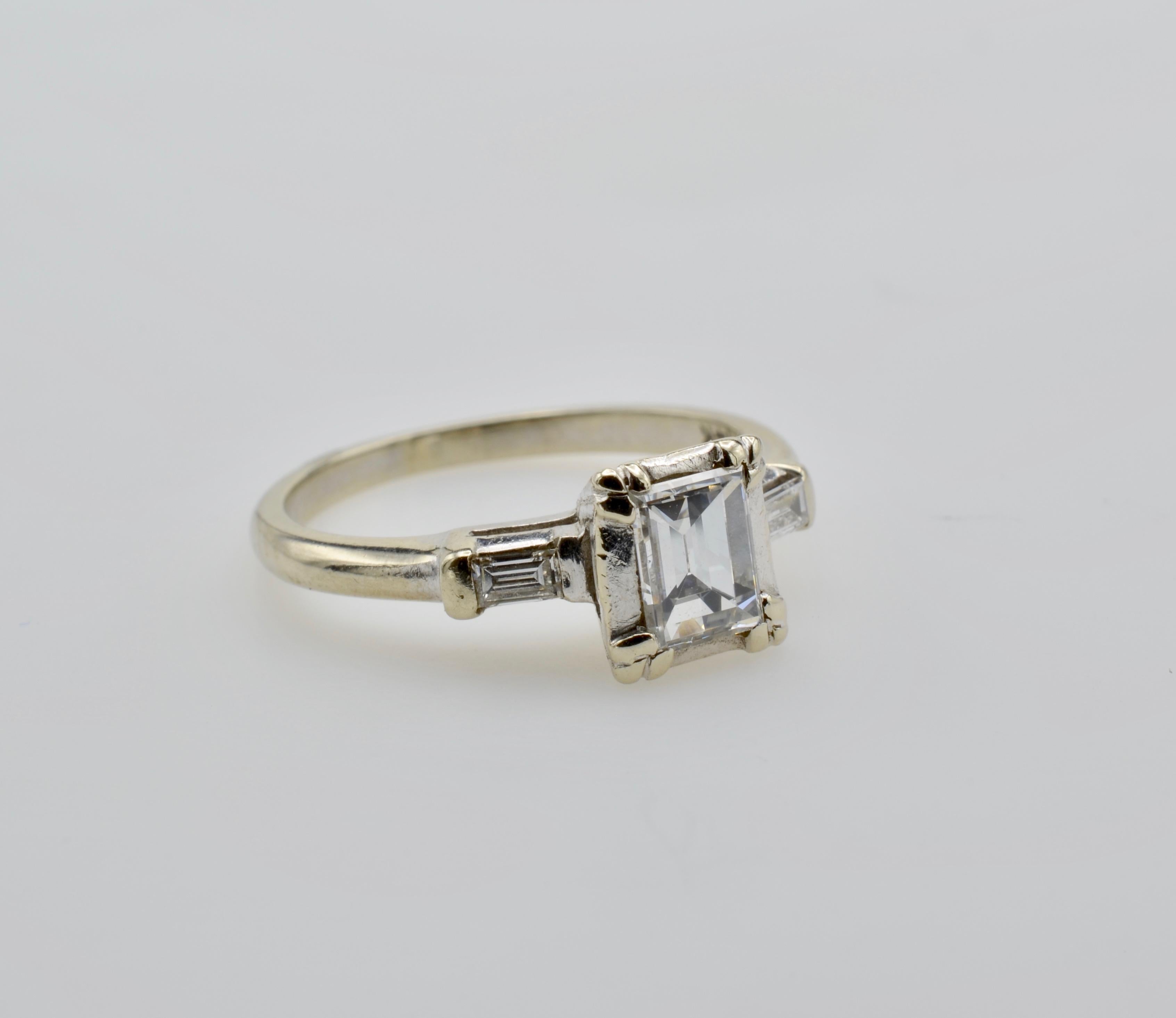 This stunner has an emerald cut (0.40 tw ) diamond quality VS2 and color G. The two side baguettes are 0.10 tw and beautifully compliment the clean and vibrant center diamond. Classic and sleek this engagement ring is simply elegant. The ring size