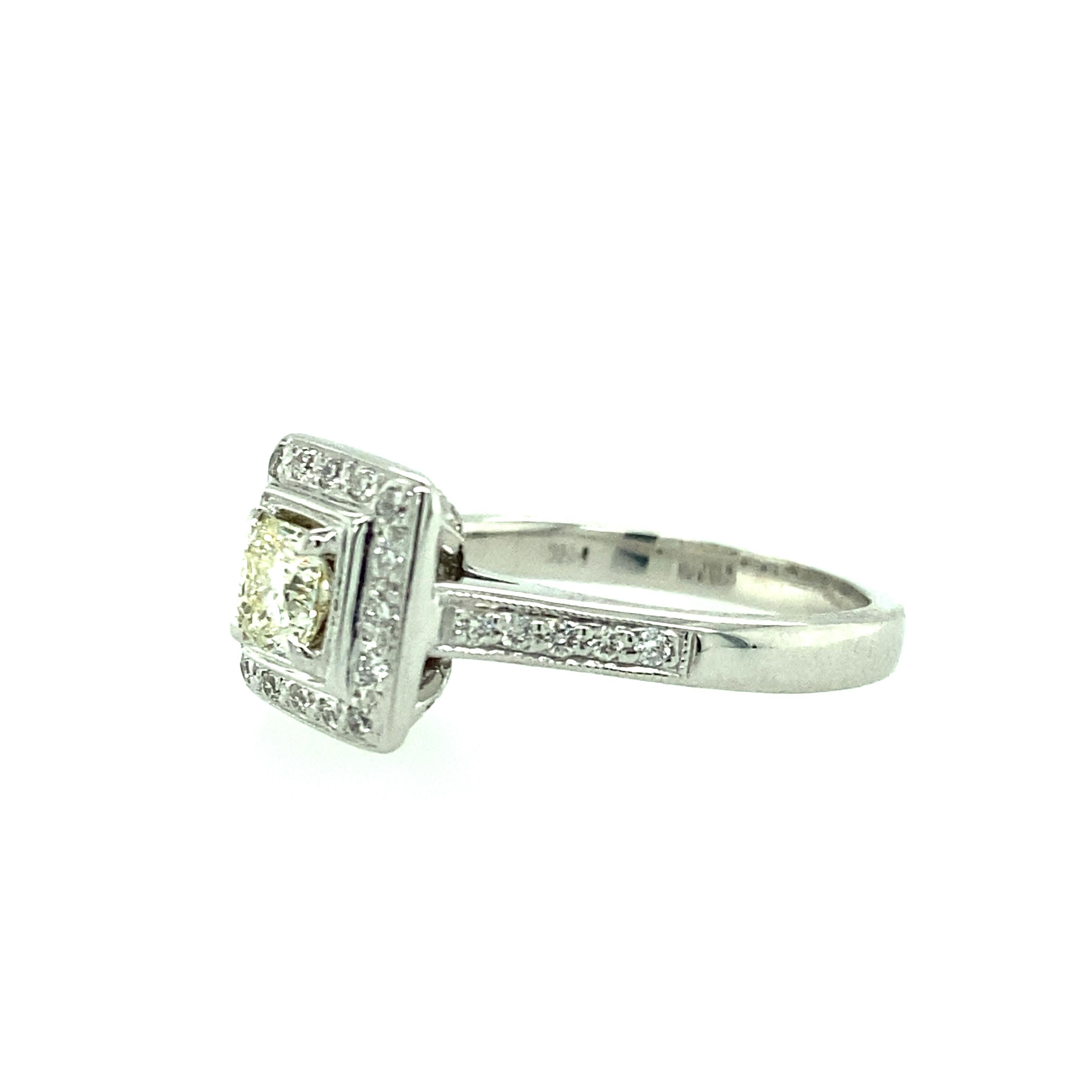 One 14 karat white gold (stamped 14K) engagement ring set with one cushion cut diamond, 0.51 carat total weight with O color and VS2 clarity.  The ring is surrounded by thirty-six round brilliant diamonds, 0.34 carat total weight with matching I/J