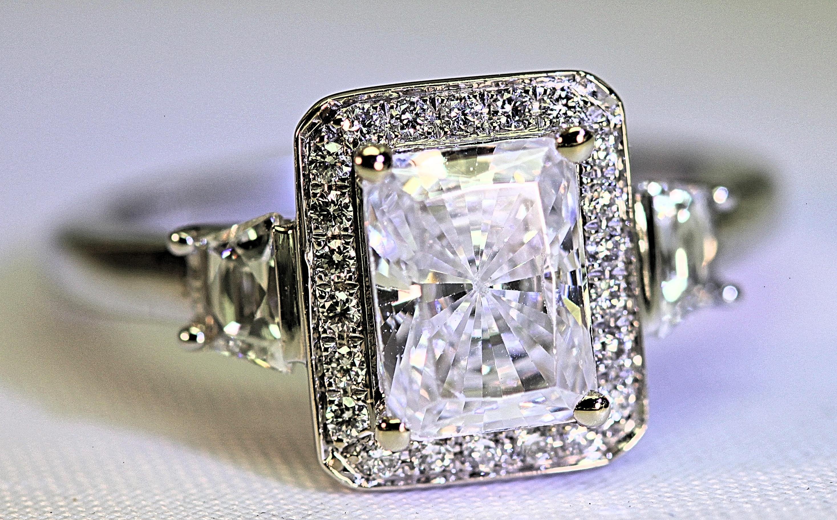 This beautiful semi mount will hold an 8 mm x 6 mm diamond or colored stone.  The ring is a heavy mounting with .44 carat total weight of two trapezoid diamonds and .17 carat total weight of round brilliant cut diamonds. The diamonds are fine white