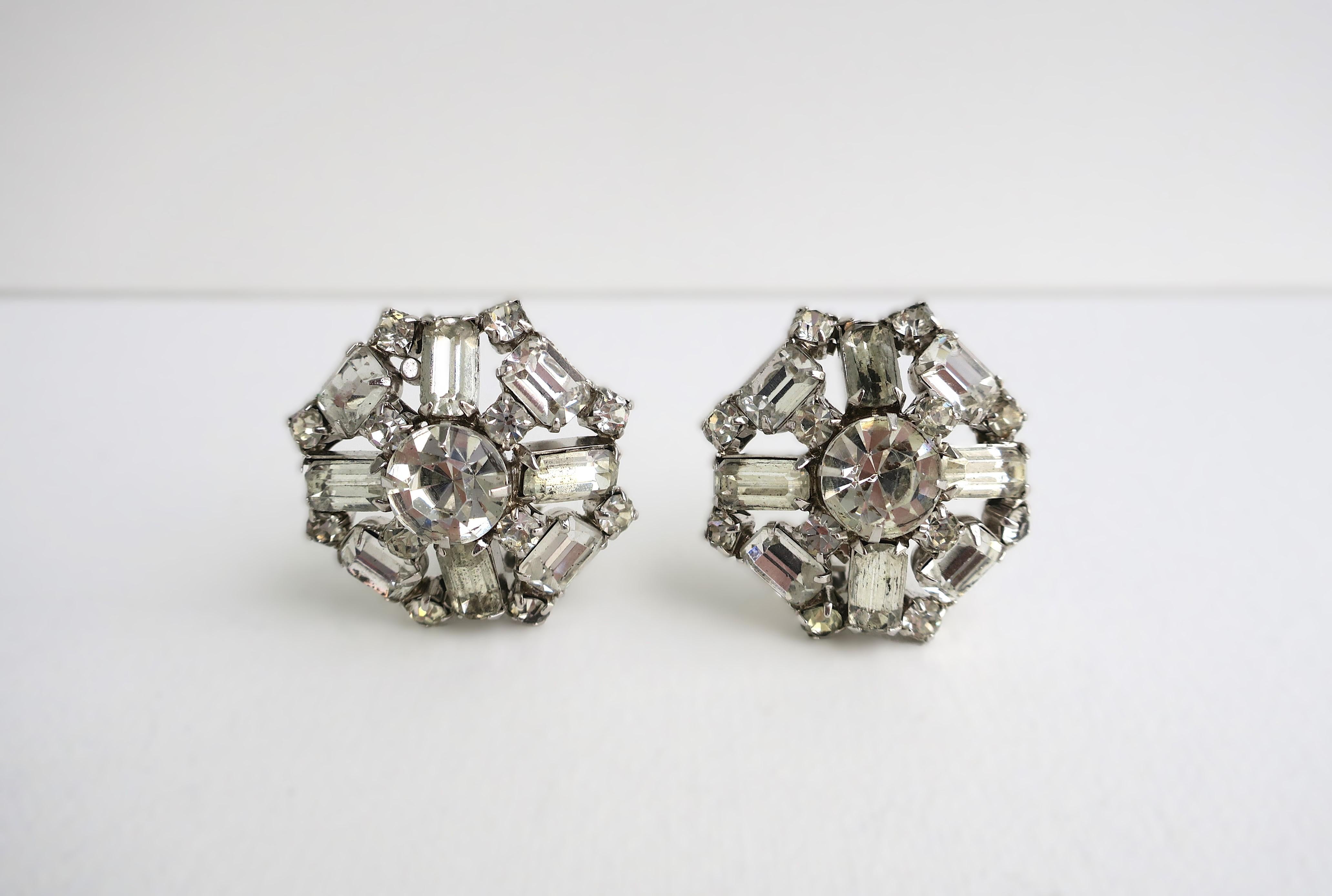 A beautiful vintage pair of round diamond-esque rhinestone earrings, circa mid-20th century. Earrings are made up of round brilliant and emerald cut rhinestones. A beautiful pair to dress up or down. Very good condition as shown in images. Diameter: