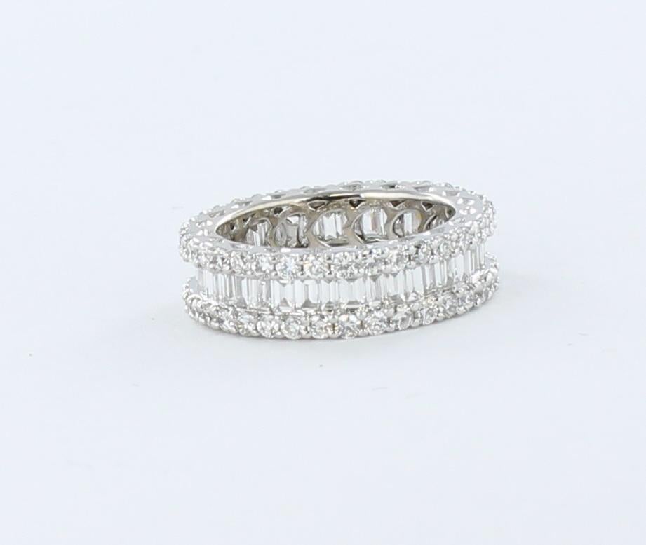 The simple design of this 18 karat white gold eternity band defines classic elegance.  A row of baguettes encircles the finger and is trimmed on both sides with round diamonds all totaling 2.25 carats.  This sparkling band is 3/16 inch wide on the