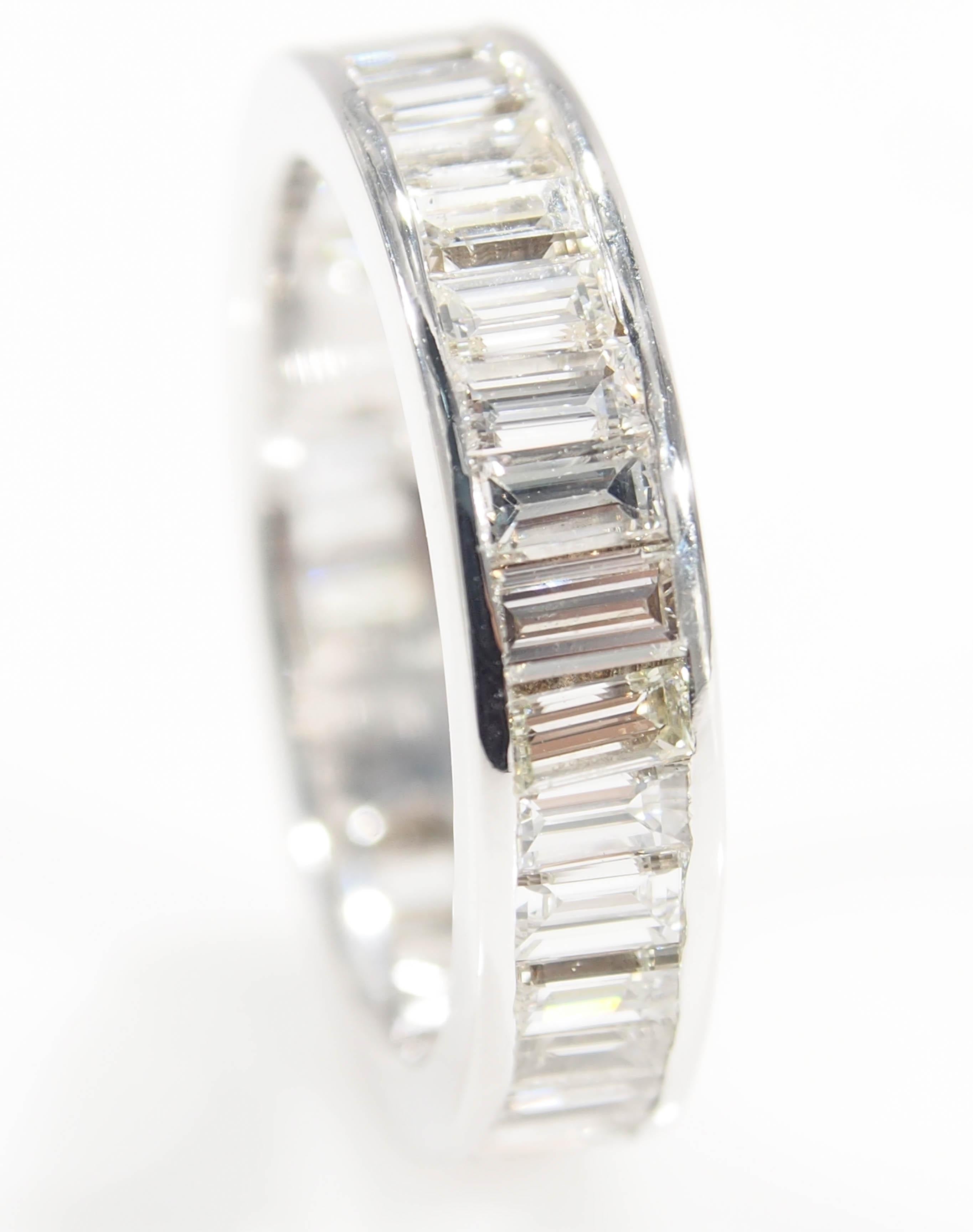 This is a unique Diamond Eternity Band as it is set with (33) Emerald Cut Diamonds   G-H in Color, VS in Clarity for an approximate total weight of 2.10ctw. Fabricated in 10K White Gold, 1/8 inch in width and is a size 5.25. The ring weighs 2.95g.