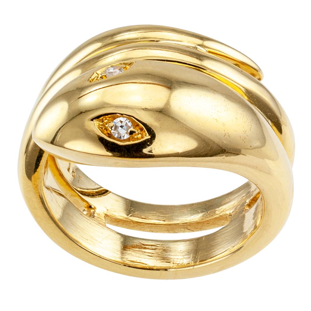 Gold snake ring with diamond eyes circa 1960. Designed as a snake coiled around the finger with diamond-set eyes totaling approximately 0.06 carat, approximately G – H color and VS clarity, crafted in 18-karat yellow gold. We love the sturdiness of