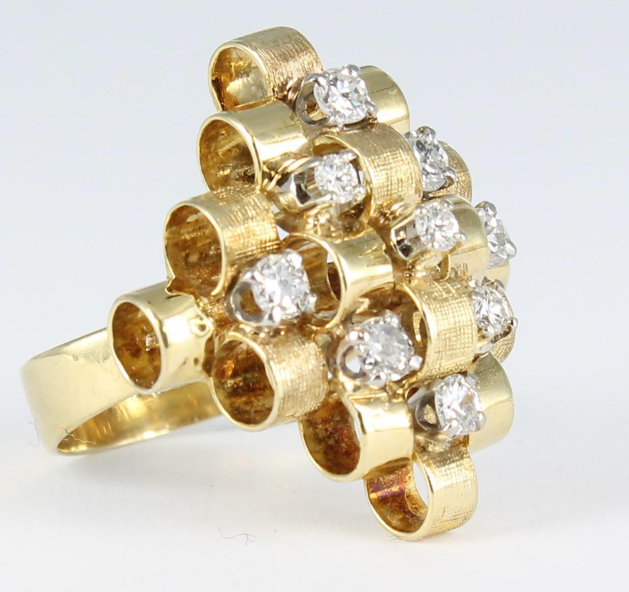 This geometrically designed ring is a showstopper.   Circles of 14 karat polished and textured gold are stacked to a height of .38 inch on the finger.  There are 9 round diamonds, .50 carat total weight, dotting the circles.  This dazzling ring is 1