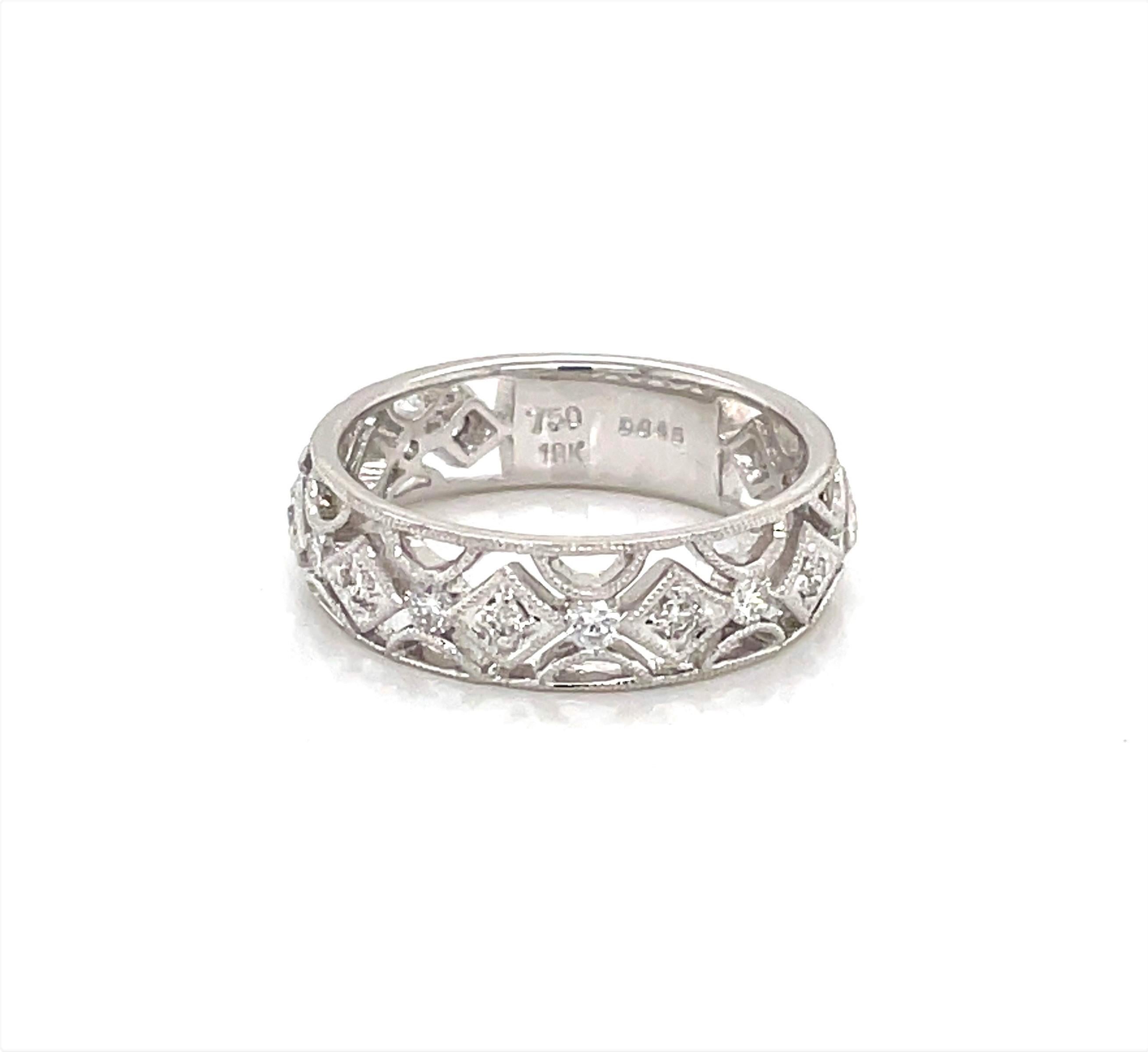 Sixteen diamonds wrapped in elegantly finished filigree with a beaded detail in 18 karat white gold give this vintage inspired ring its sparkle. With .51 carats of round faceted H/VS diamonds, this glistening 5.5mm wide band is thoughtfully suited