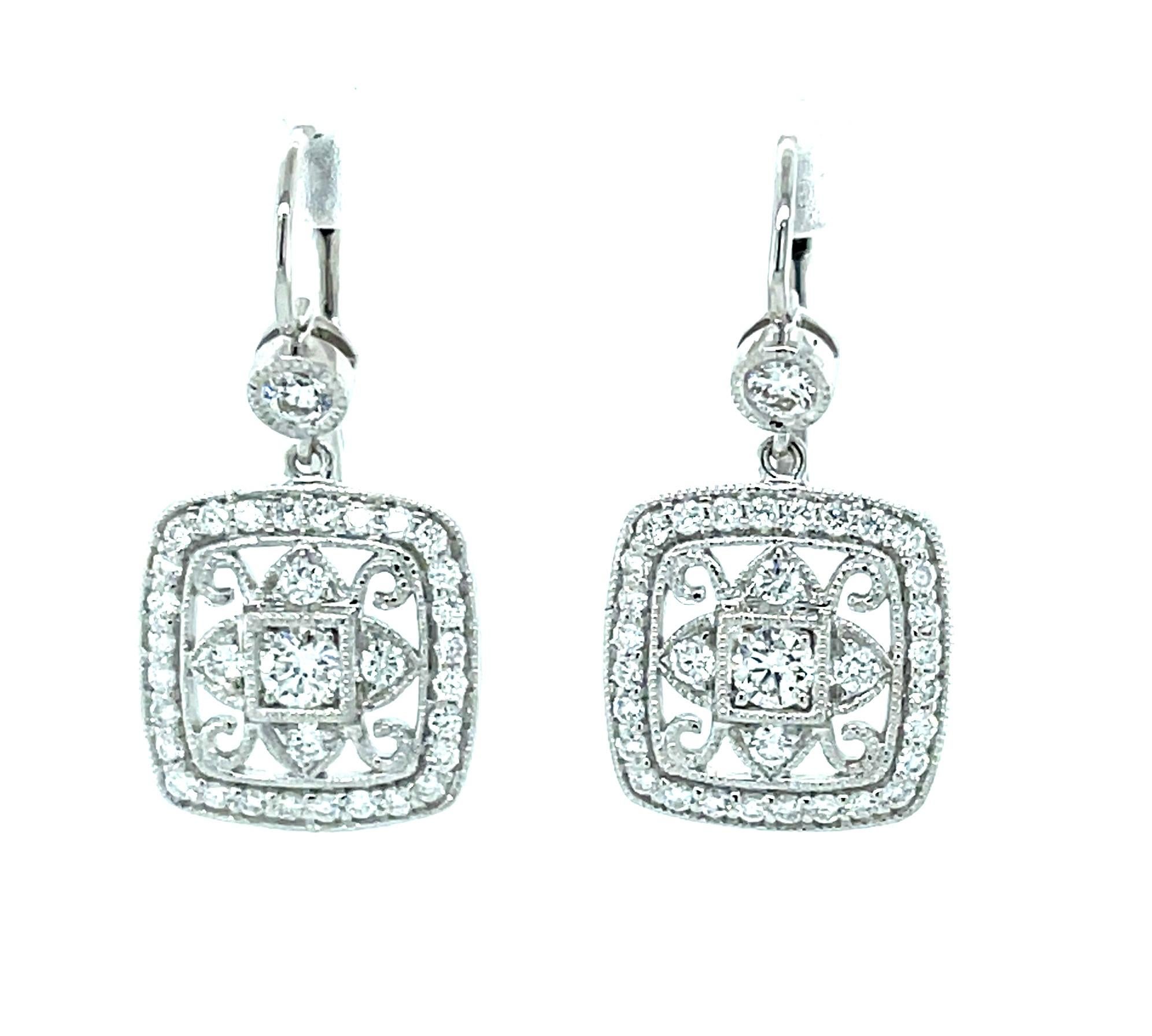 Stunning geometric lines and delicate curves form the eye-catching shape of these gorgeous 18 karat white gold  earrings. Round brilliant-cut white diamonds sparkle throughout the intricate design, drawing attention to masterful craftsmanship and