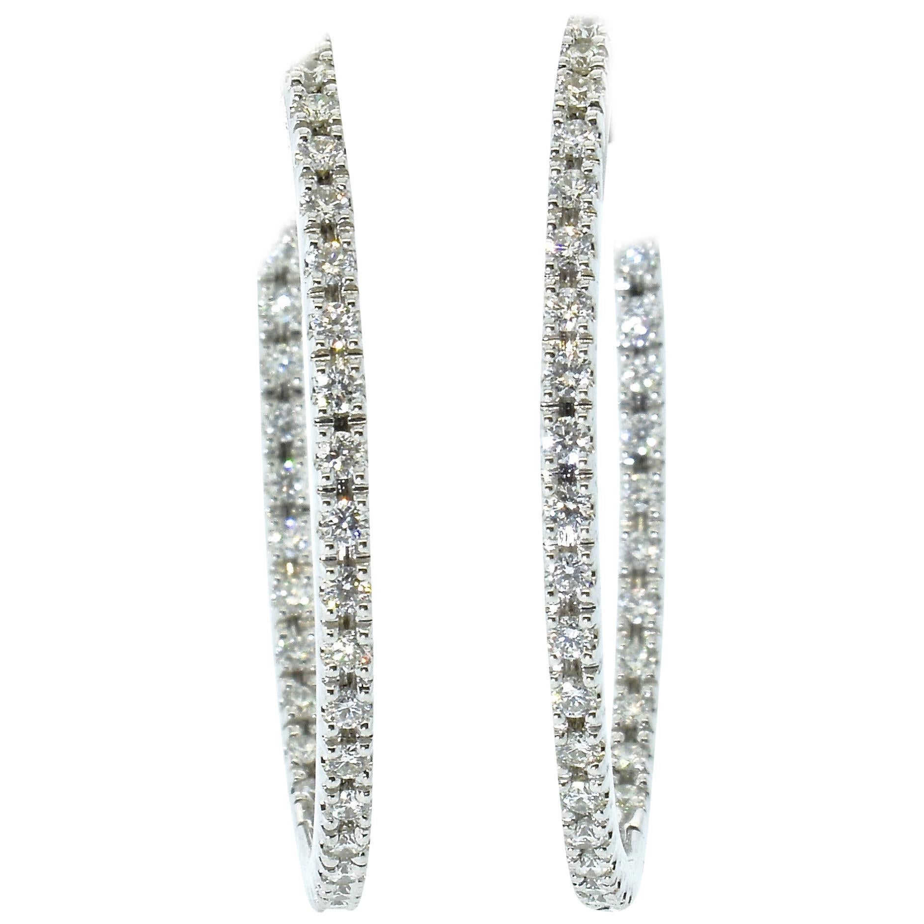 Diamond hoops in 18K white gold, with 74 round fine brilliant cut diamonds, bead set, all well matched and finely cut.  The diamonds are all near colorless (G/H), and very slightly included (VS).  The diamond weight is 1.50 cts.    Diamonds are set
