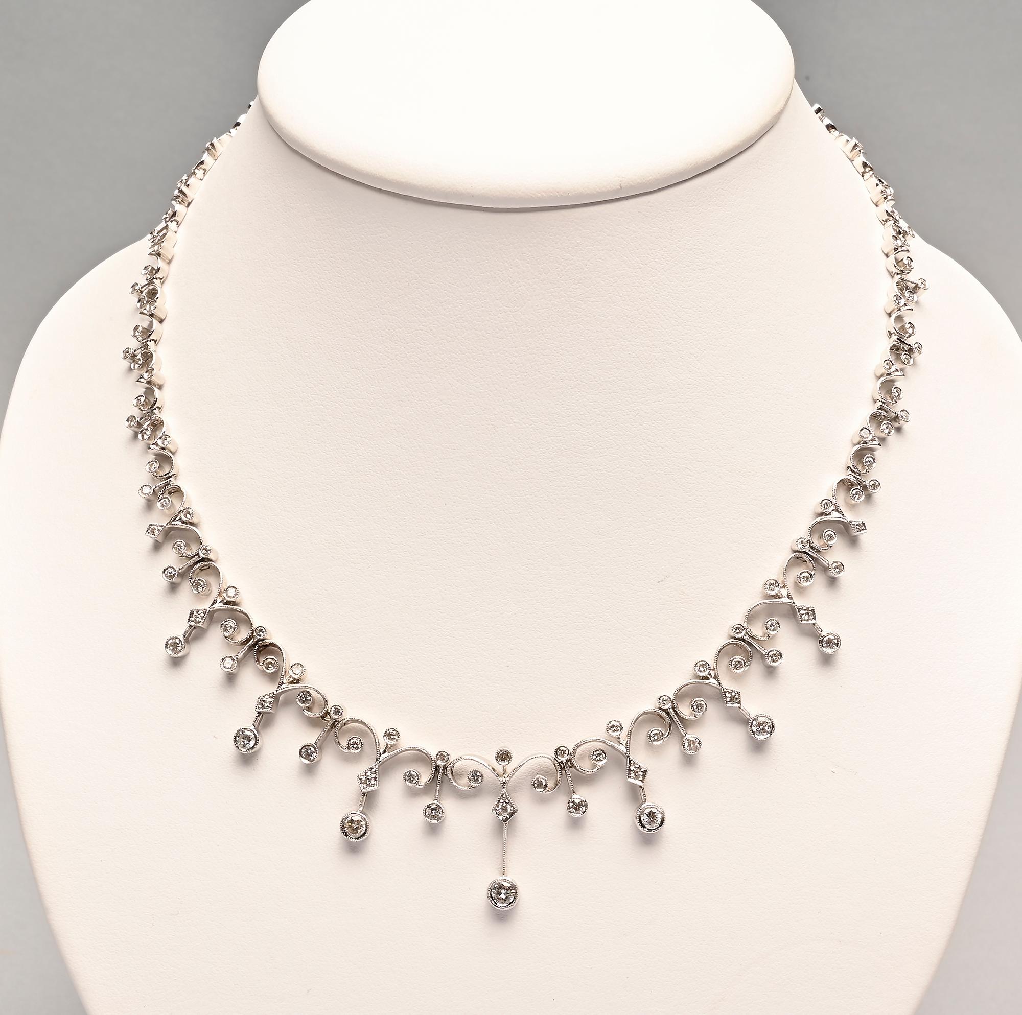 Delicate and graceful diamond necklace with curved links much like a fleur de lis. The central links have graduated pendants. The necklace is 18.5 inches long; made of 18 karat white gold. It has a total diamond weight of approximately 5