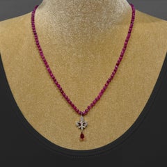 Fleur de Lis di diamanti con goccia di tormalina su una collana di rubini lampone di 22".