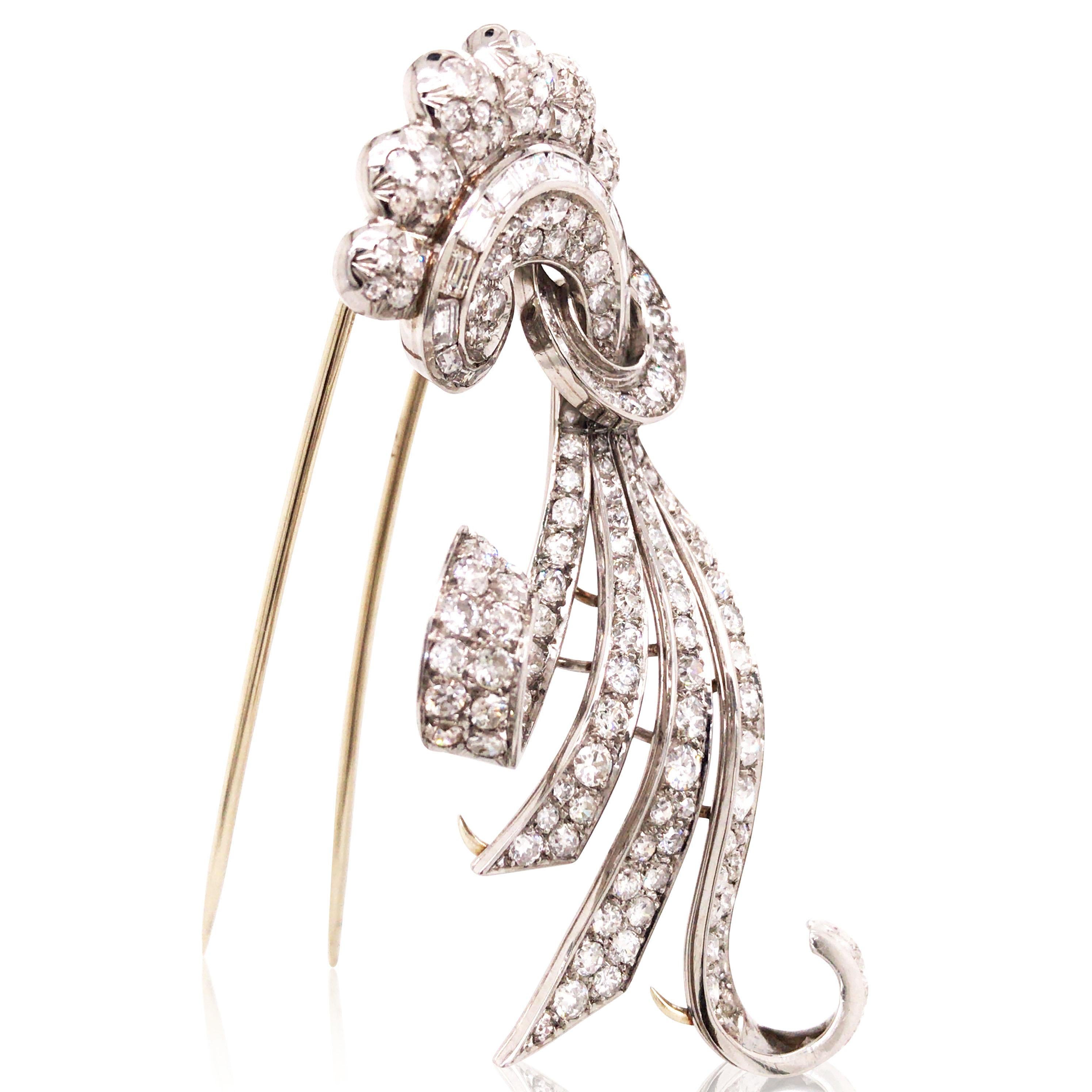 Questa spilla è un pezzo senza tempo degli anni '40 e '50, realizzata in platino e con circa 5,5 carati di diamanti incastonati. Il suo design unico, caratterizzato da curve fluide che ricordano un nastro, combina perfettamente movimento ed
